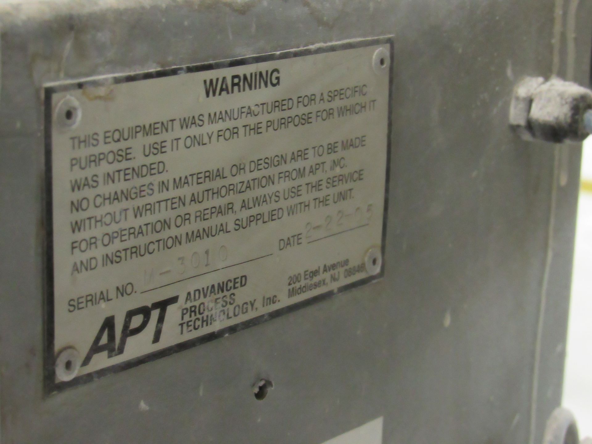 Metal plate with a warning label on industrial equipment.