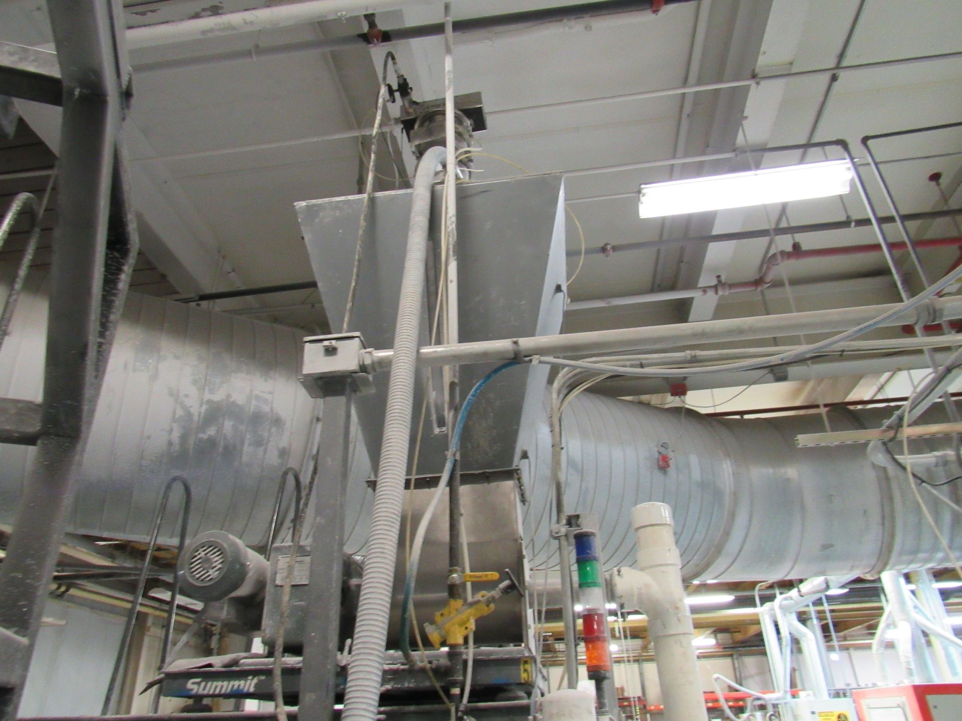 Industrial ventilation system with ductwork, electrical conduits, and machinery in a factory setting.