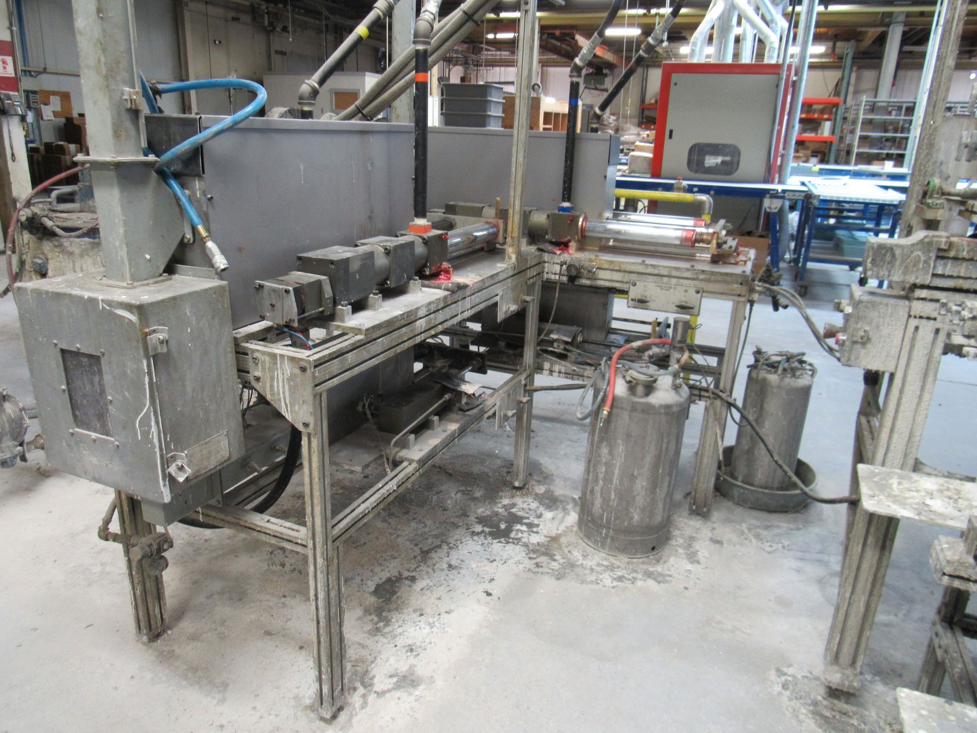 Industrial machinery, including tanks, electrical components, and metal framework, in a factory setting.