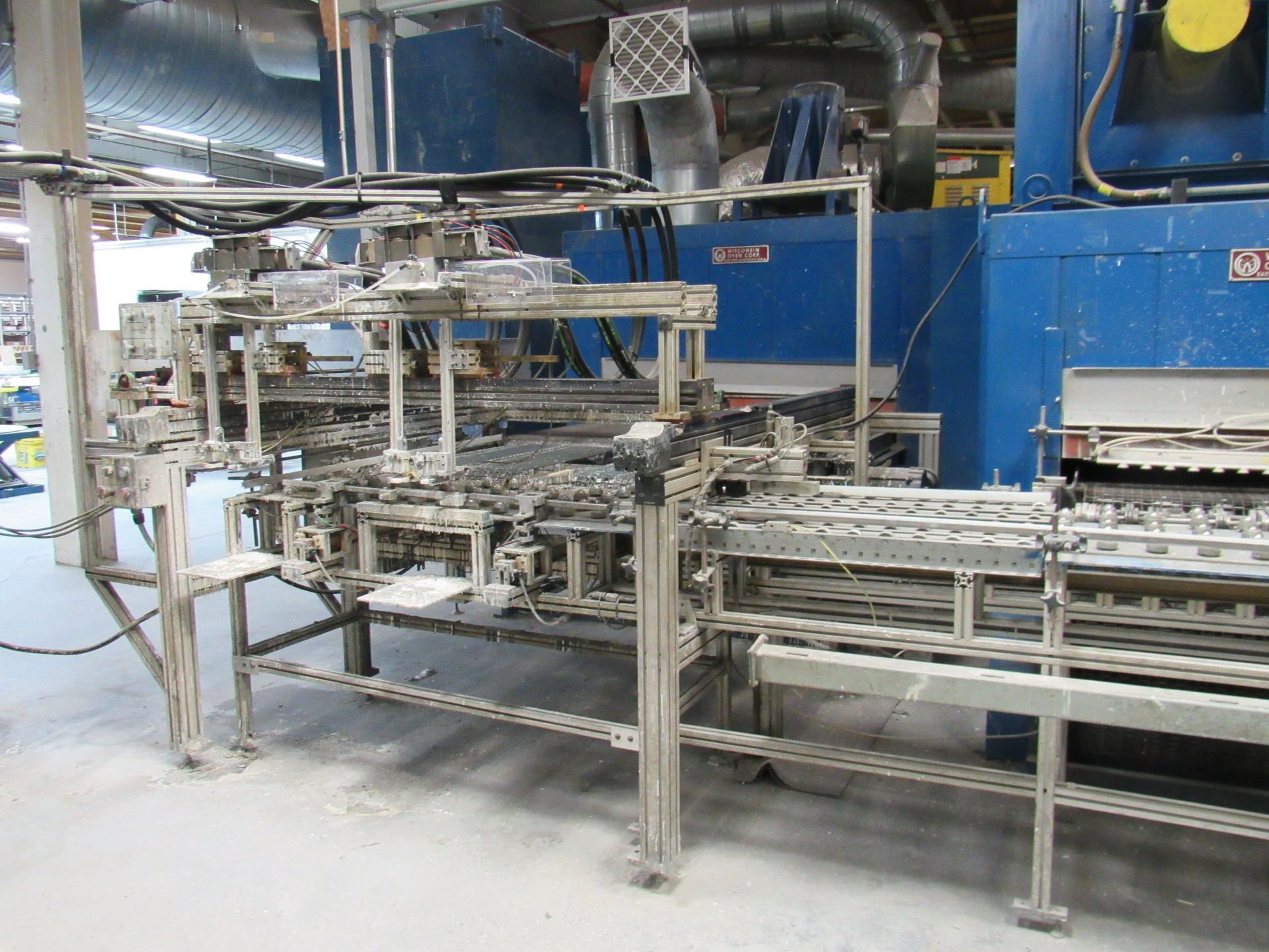 Factory machinery with conveyor belts and blue oven.