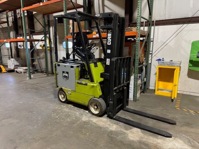 Green and black Clark forklift in a warehouse.