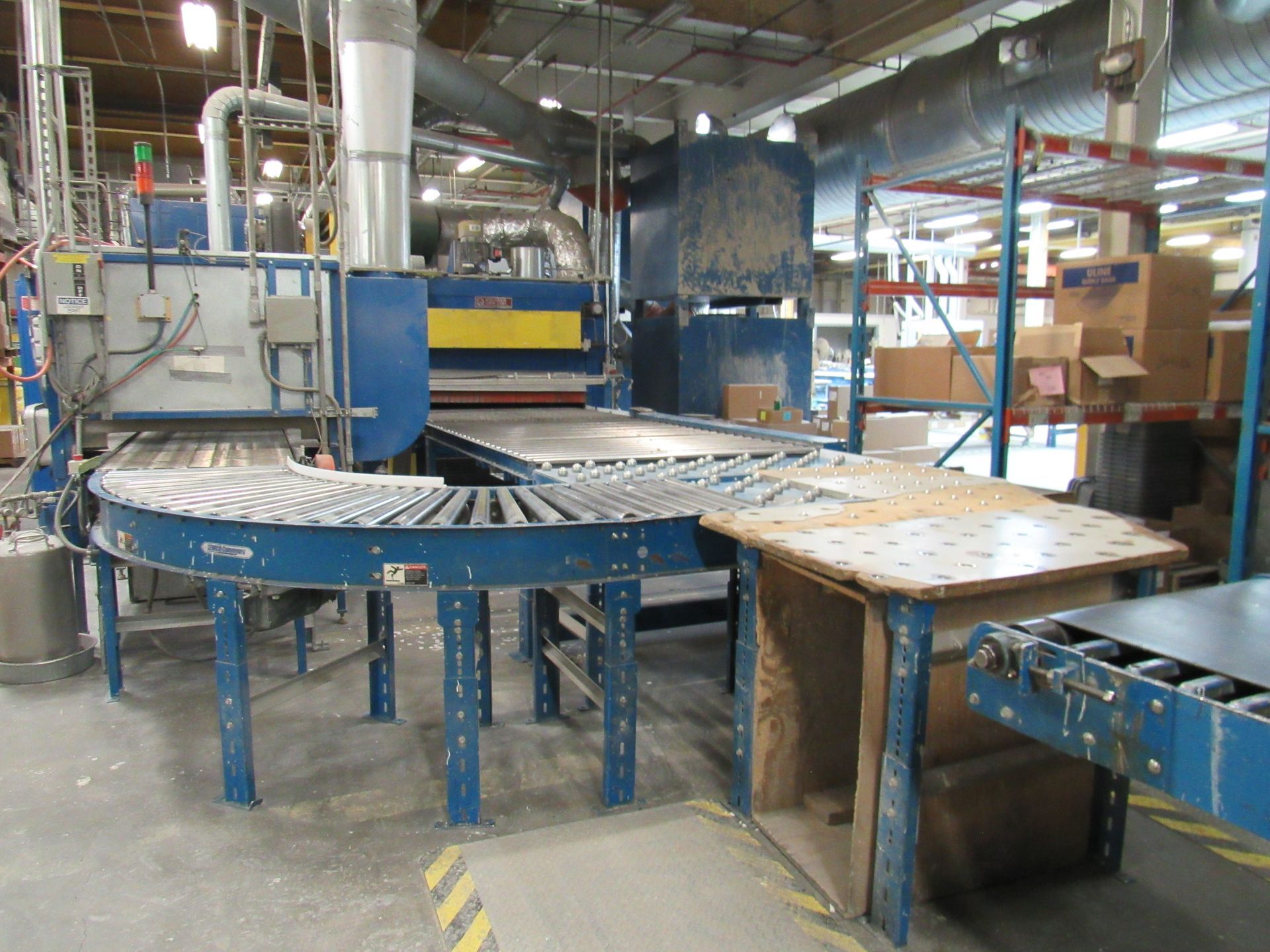 Industrial machinery with conveyor belts in a factory setting, mostly blue and beige.