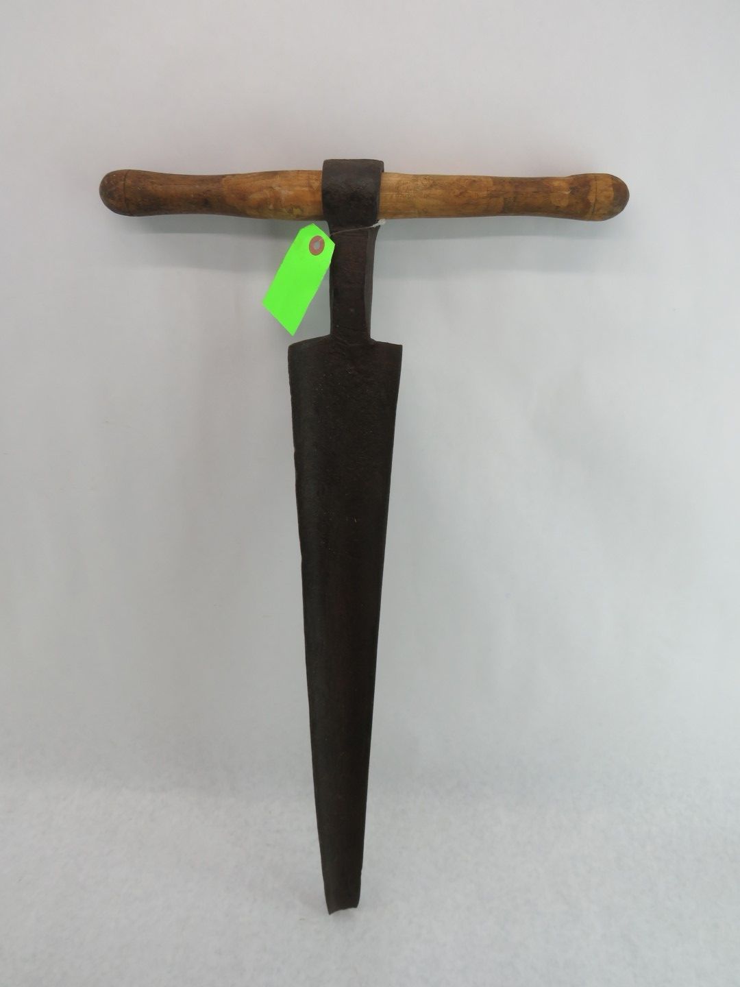 Dark metal garden dibber with a wooden handle.
