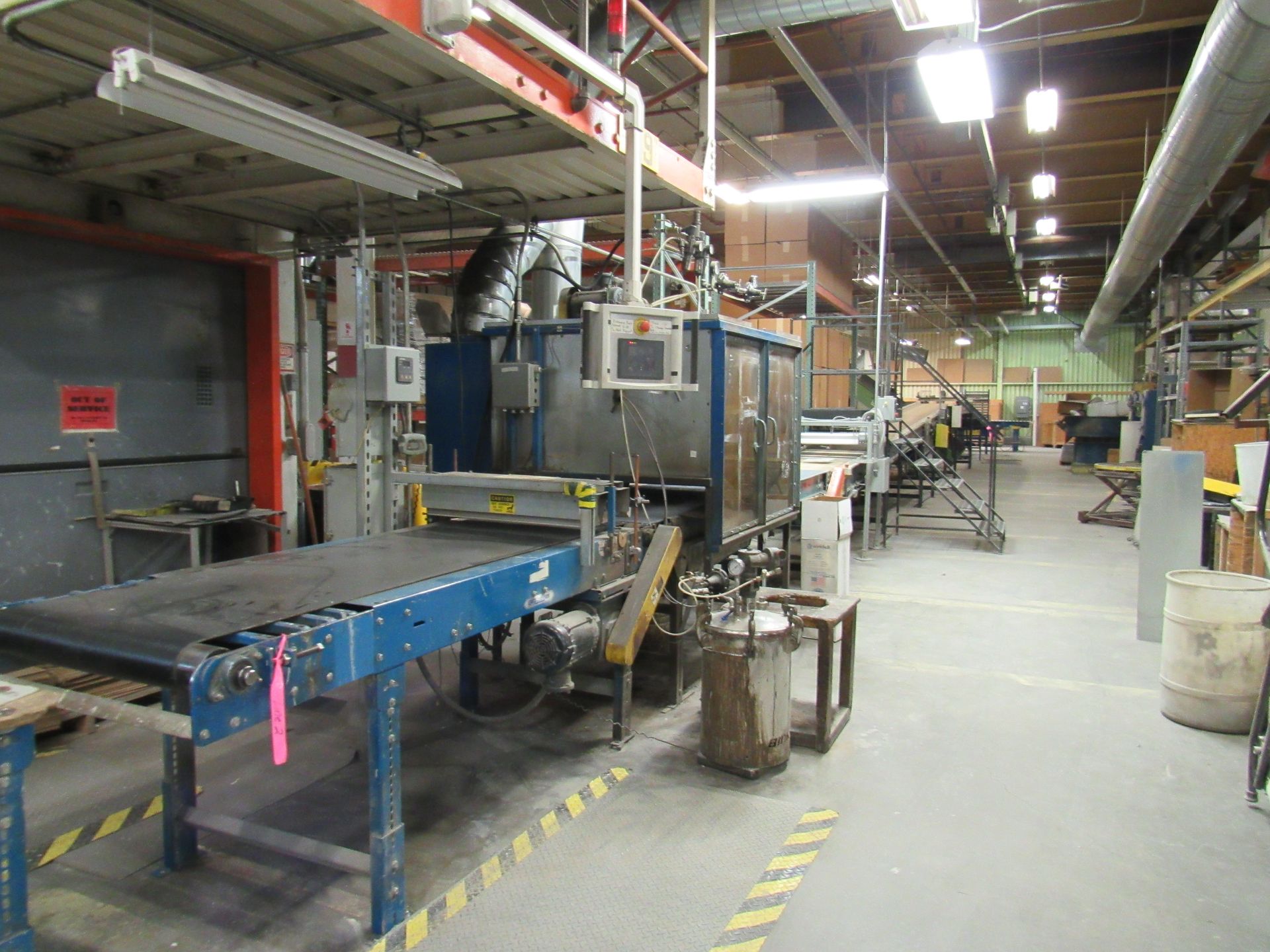 Factory machine with conveyor belt, control panel, and ventilation system. Industrial interior setting.