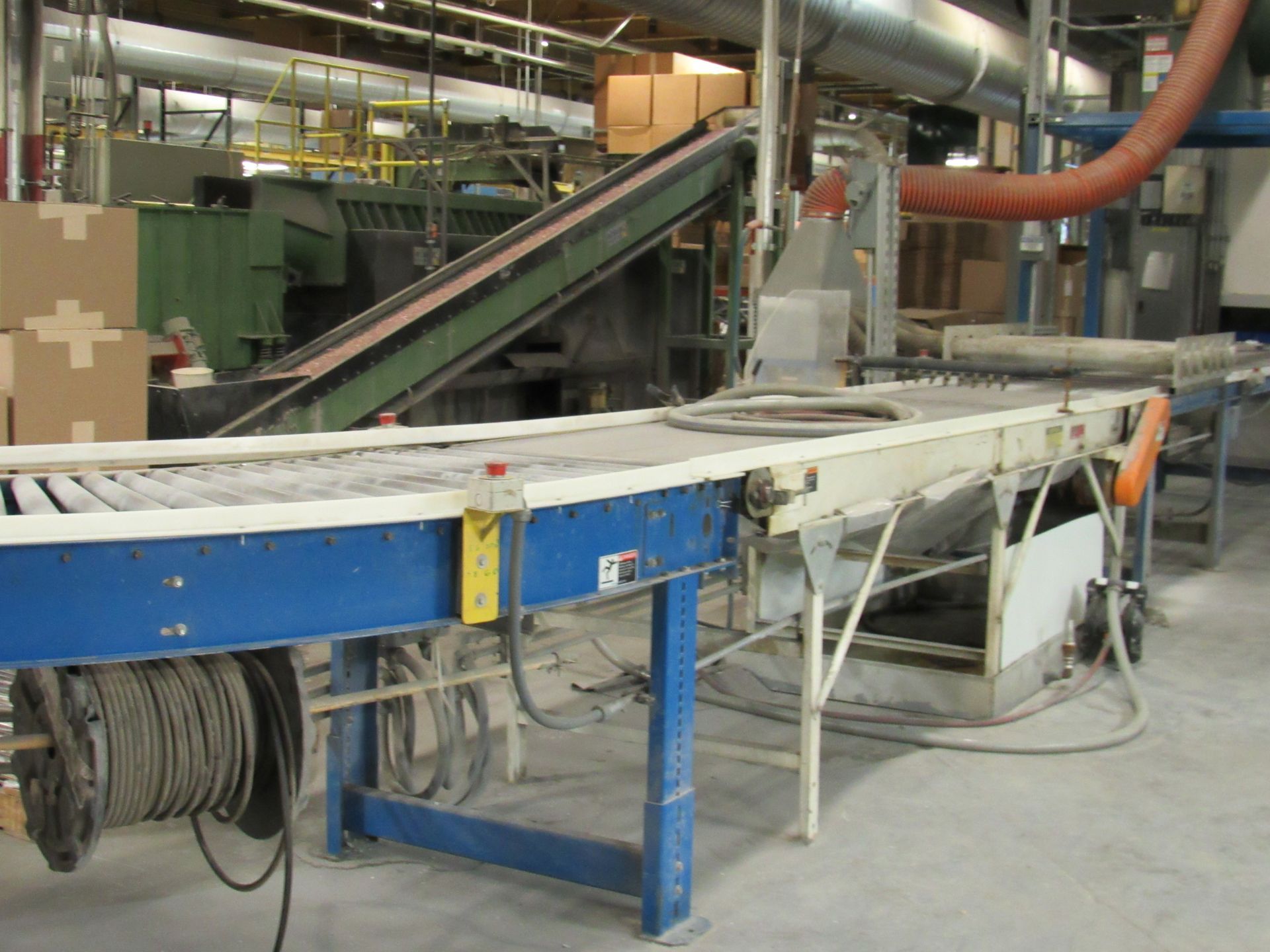 Conveyor belts in a factory setting, moving materials. Blue and white machinery, with a dust collection system.
