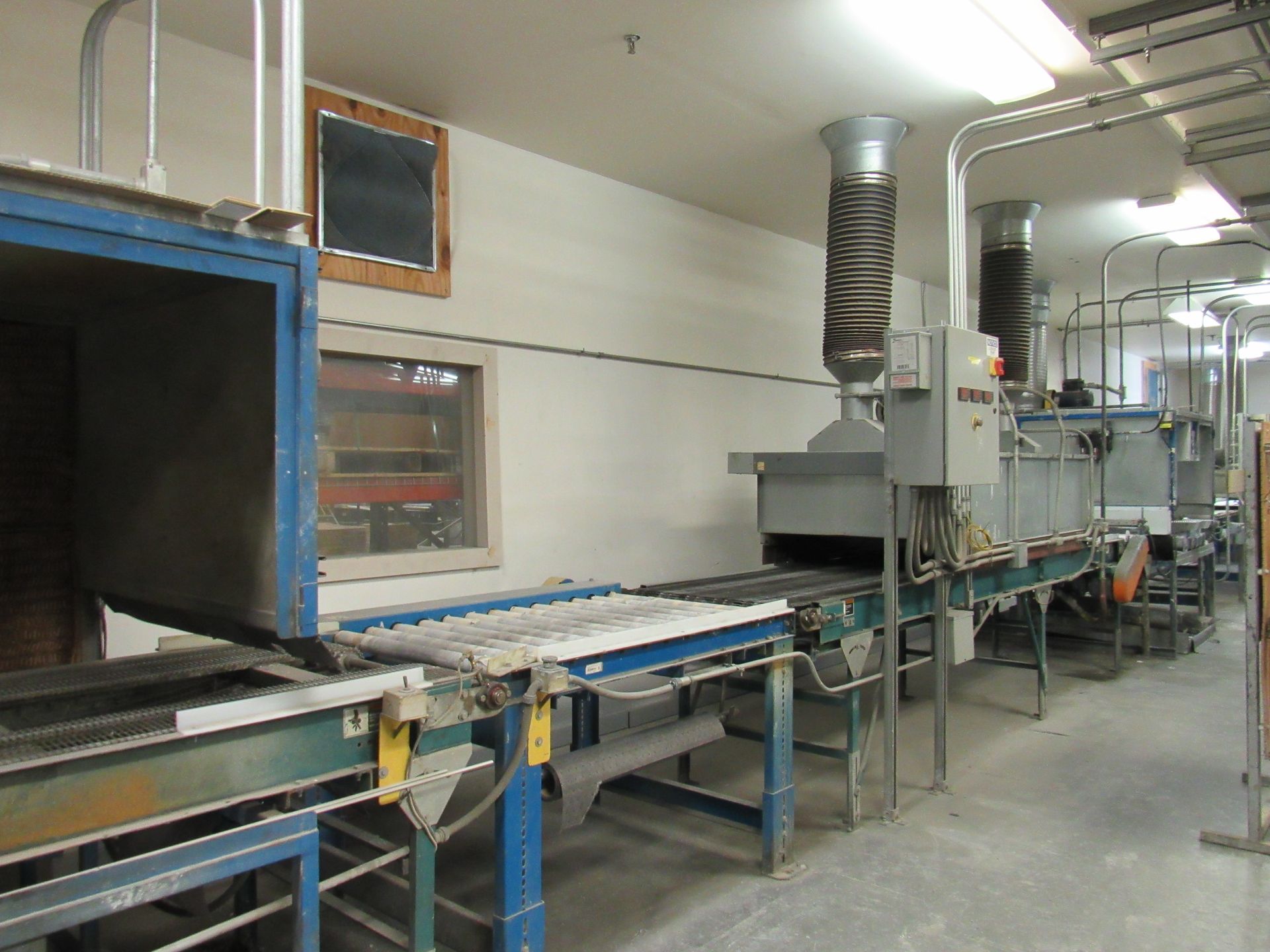 Industrial assembly line with conveyor belts, metal machinery, and ventilation ducts.