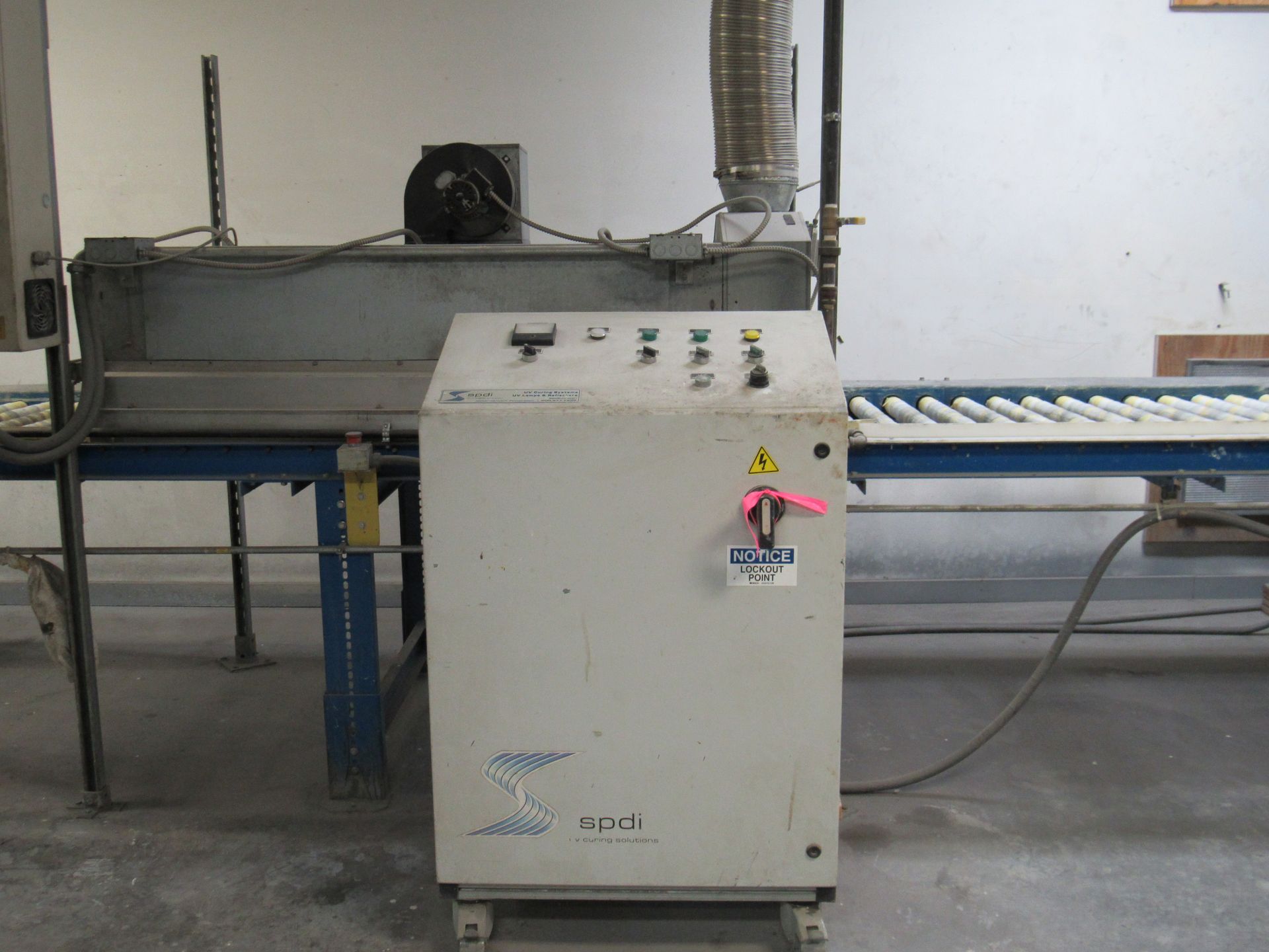 Industrial machine with control panel and conveyor belt, likely for processing products.