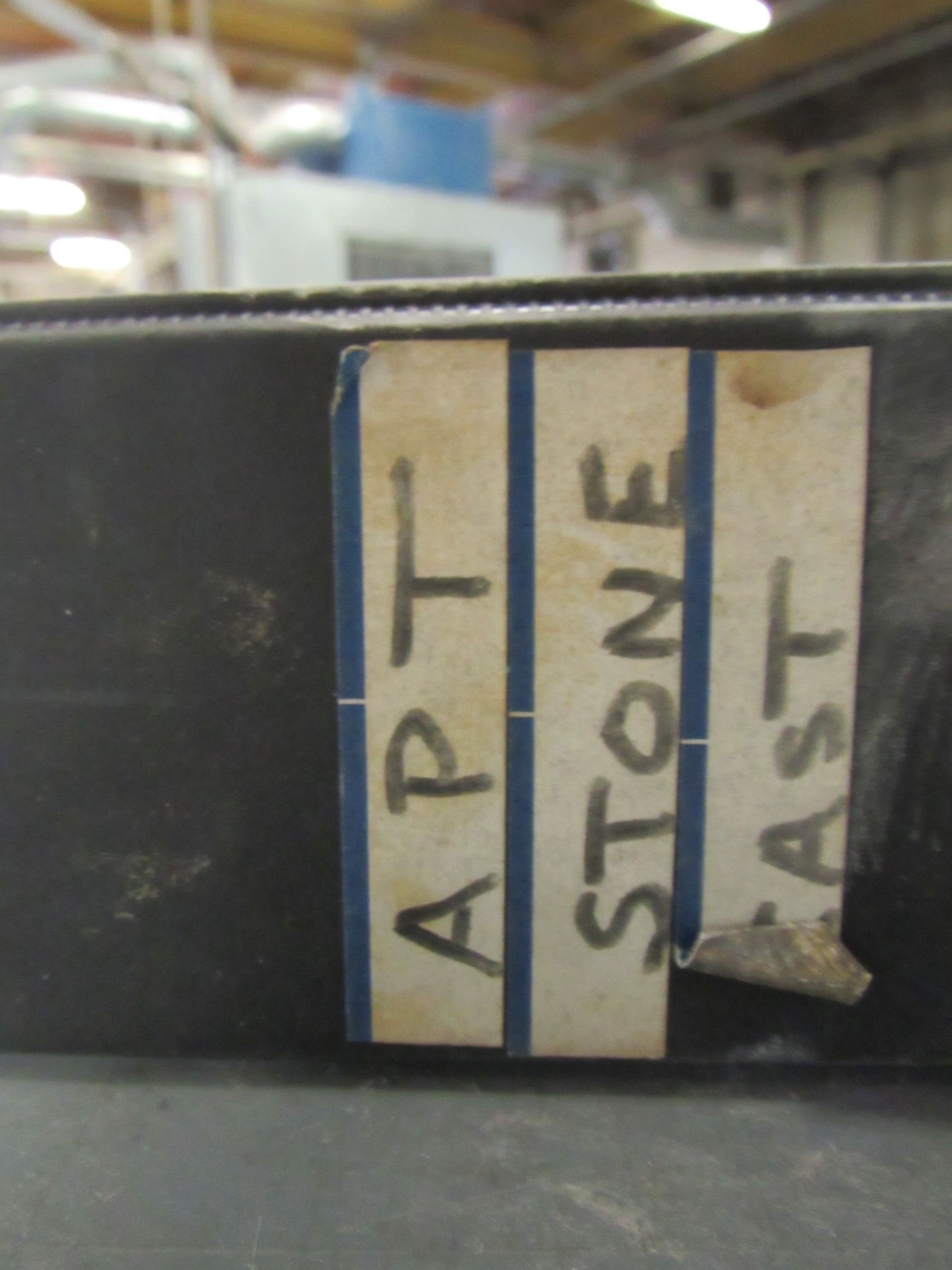 A label taped to a black surface reads 