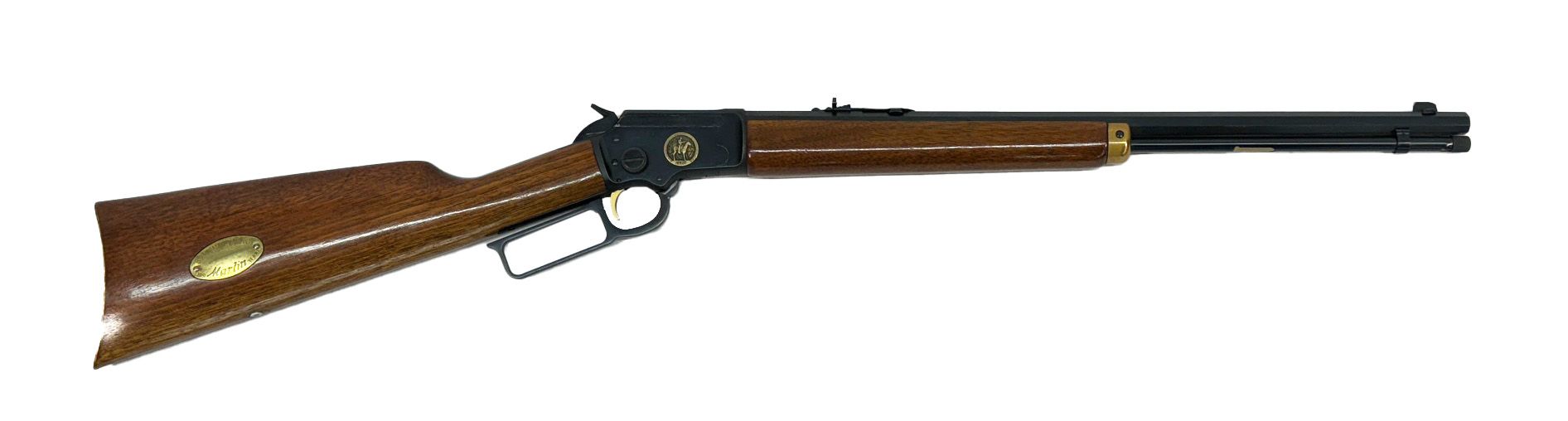Lever-action rifle with a brown stock and barrel. Black metal details and a gold emblem are visible.