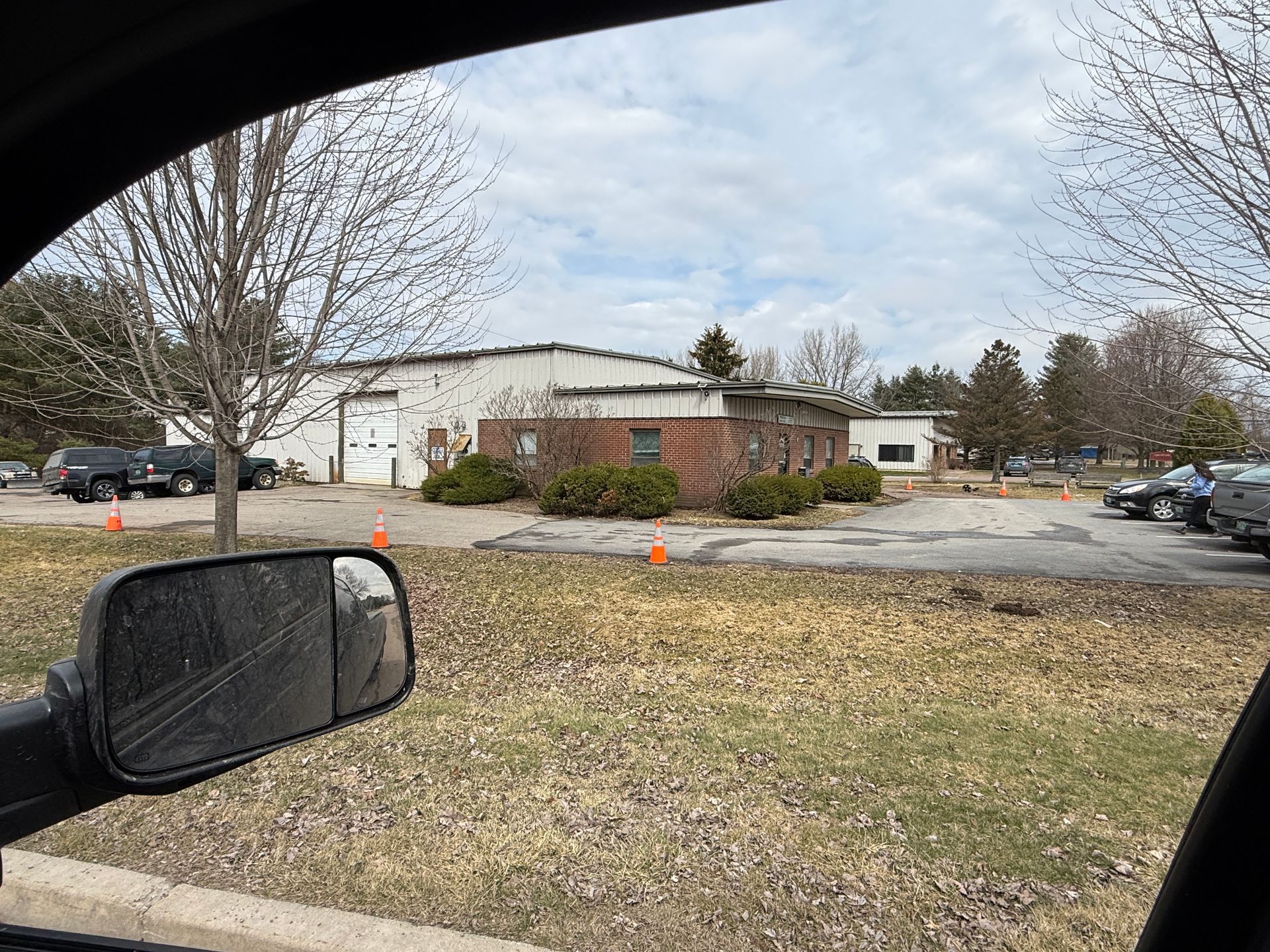Parking lot beside a low building on a cloudy day.