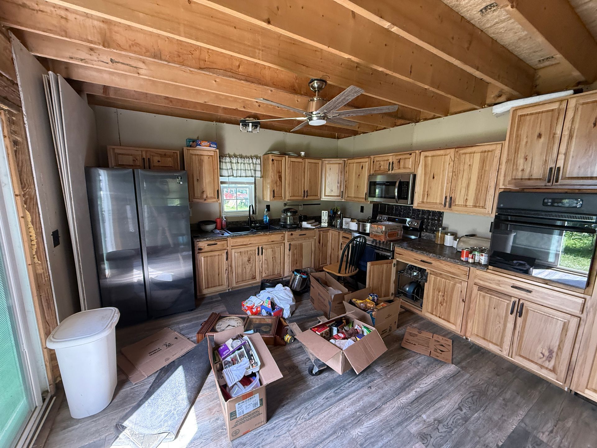 Rustic kitchen with wood cabinets, stainless fridge