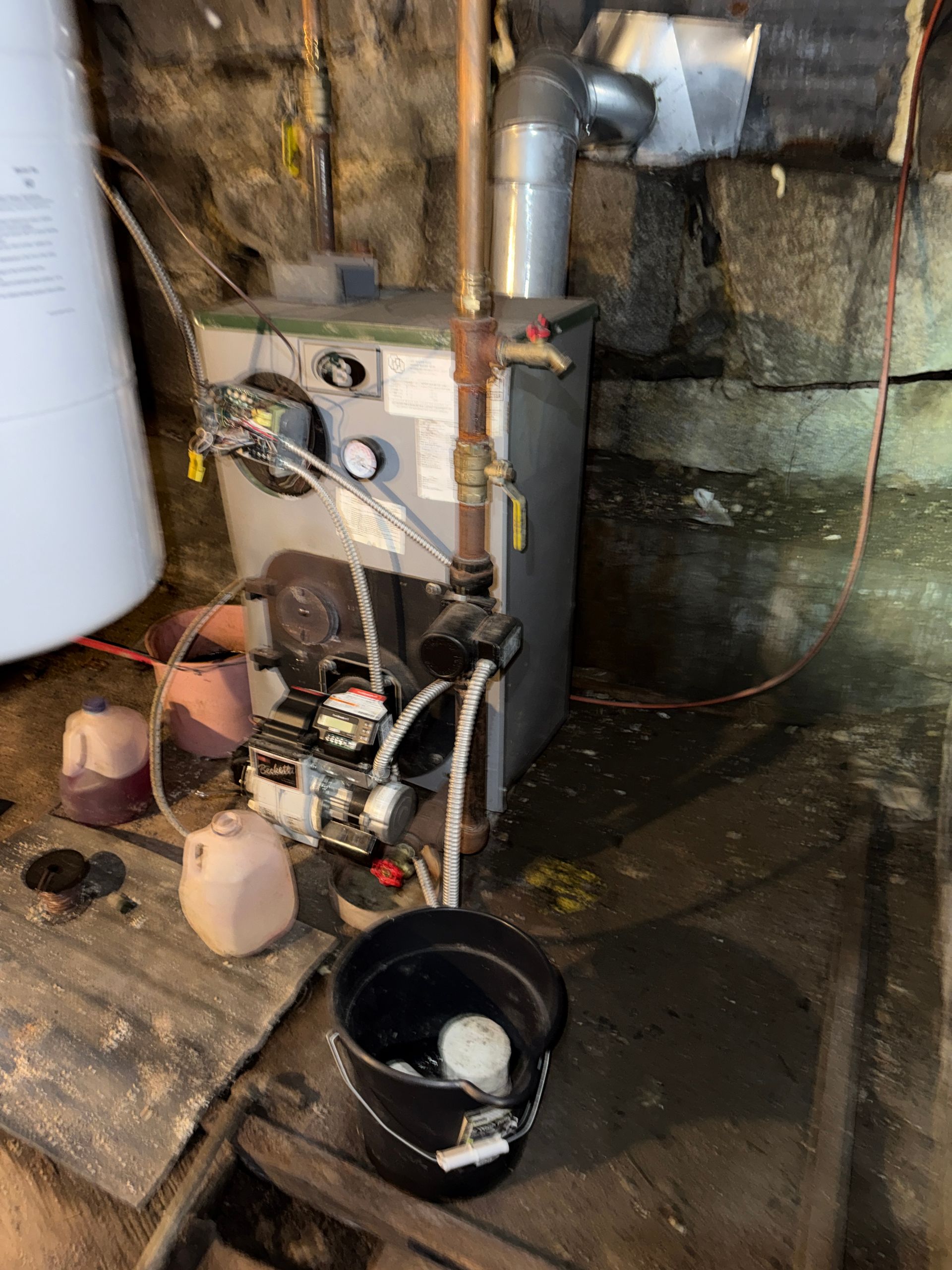 Basement utility area with furnace, pipes, wires
