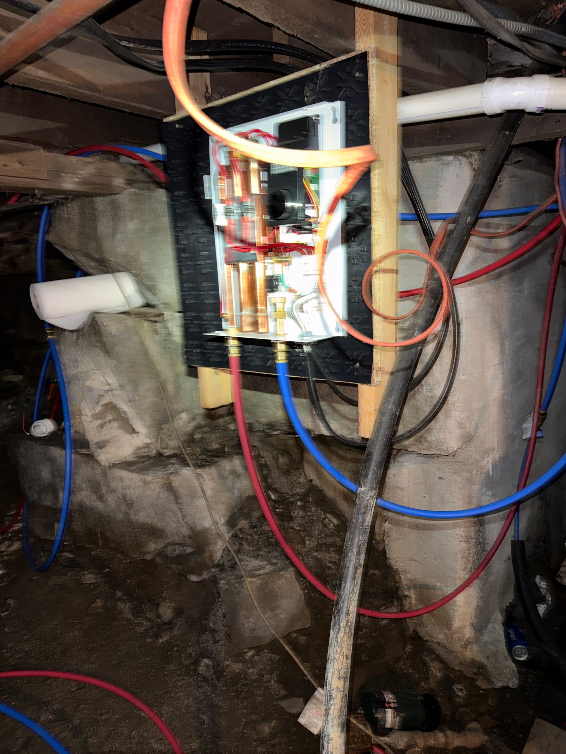 Open electrical panel with colored wires in a basement space