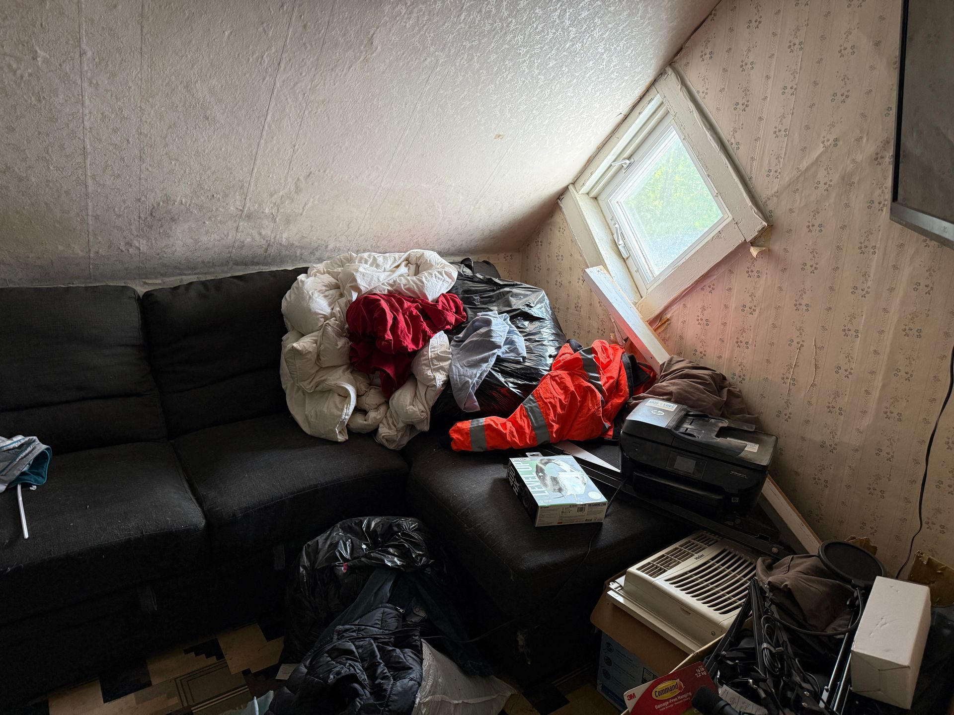 living room corner beneath a small tilted window.