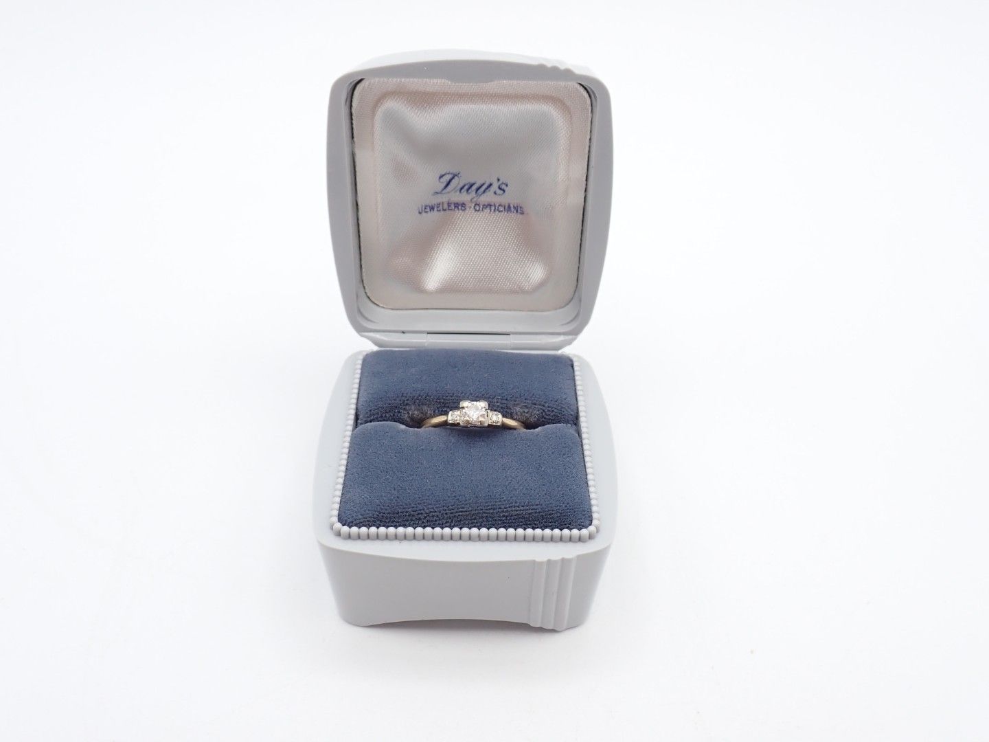 Open jewelry box with a ring on blue velvet cushion