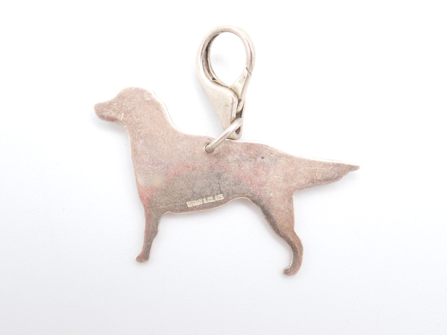 Pink dog-shaped keychain charm with a silver clasp on a white background