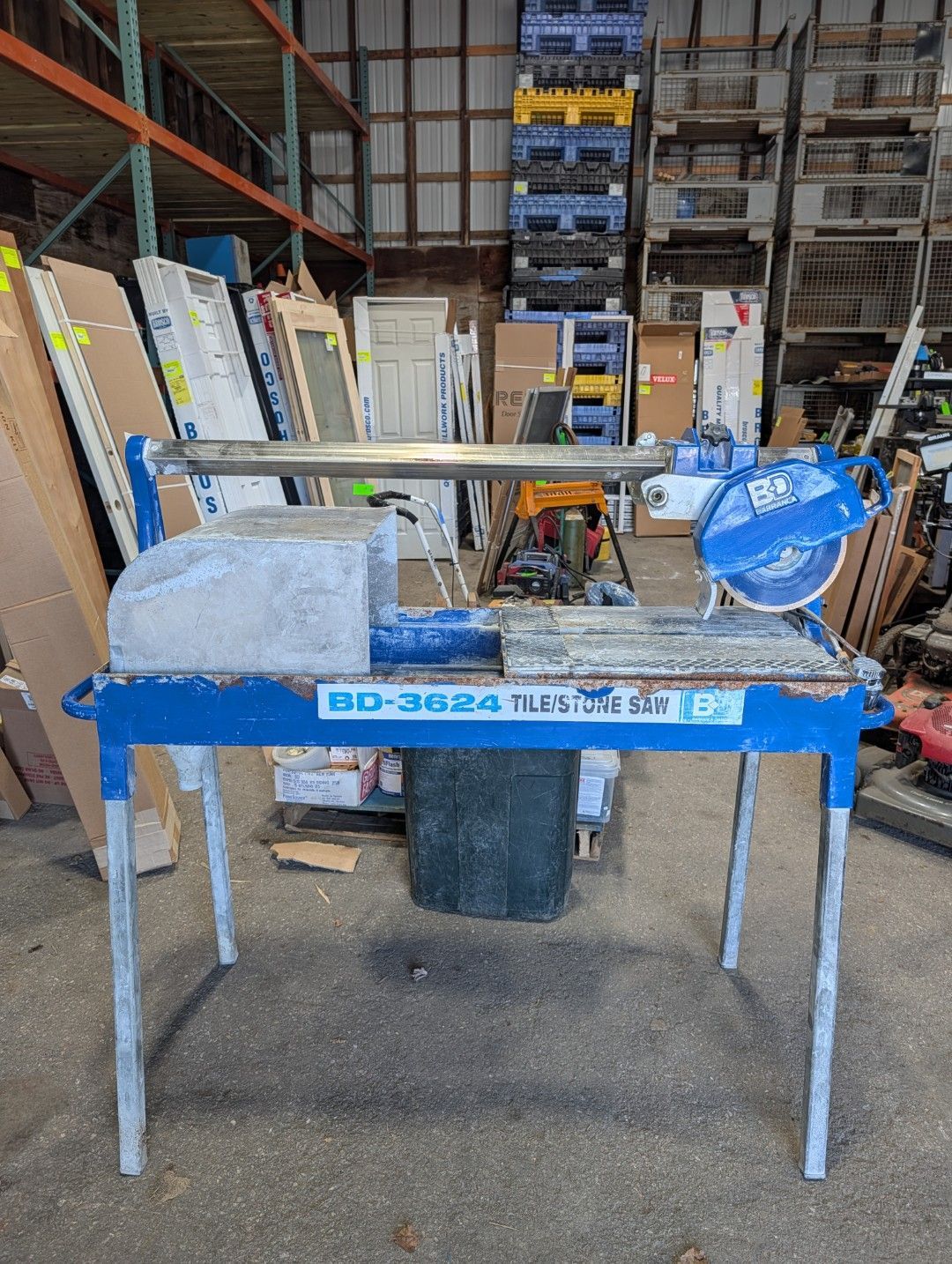 Blue tile saw on a worktable in a warehouse