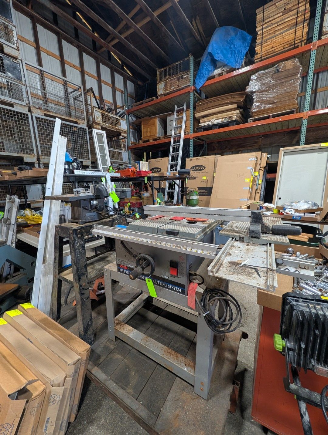 workshop with a table saw, lumber, shelving, and tools