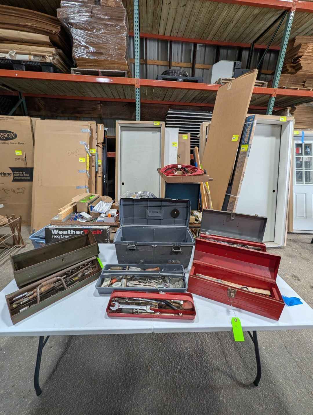 Table with open metal tool cases and small parts in a warehouse
