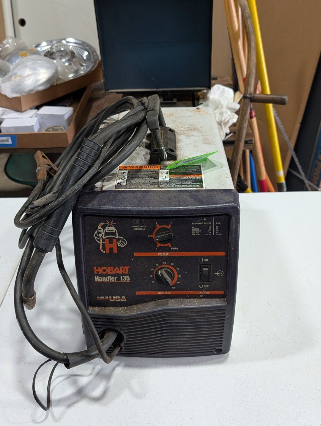 Black and orange welding machine with coiled cables