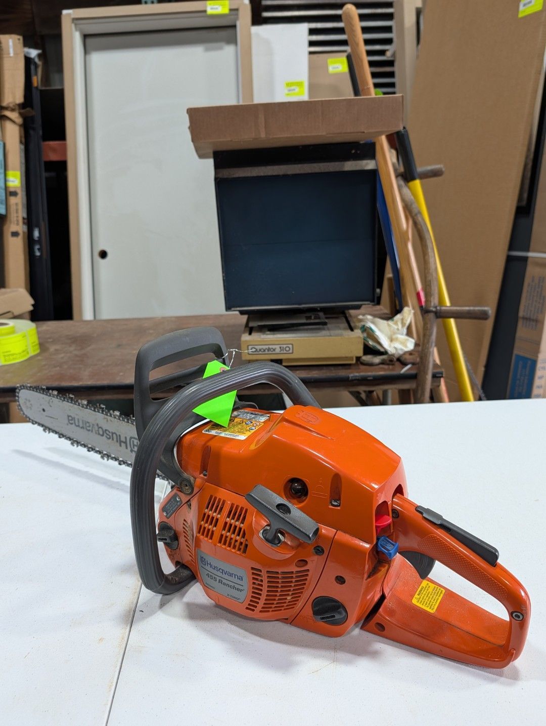 Orange chainsaw on a workbench in a workshop