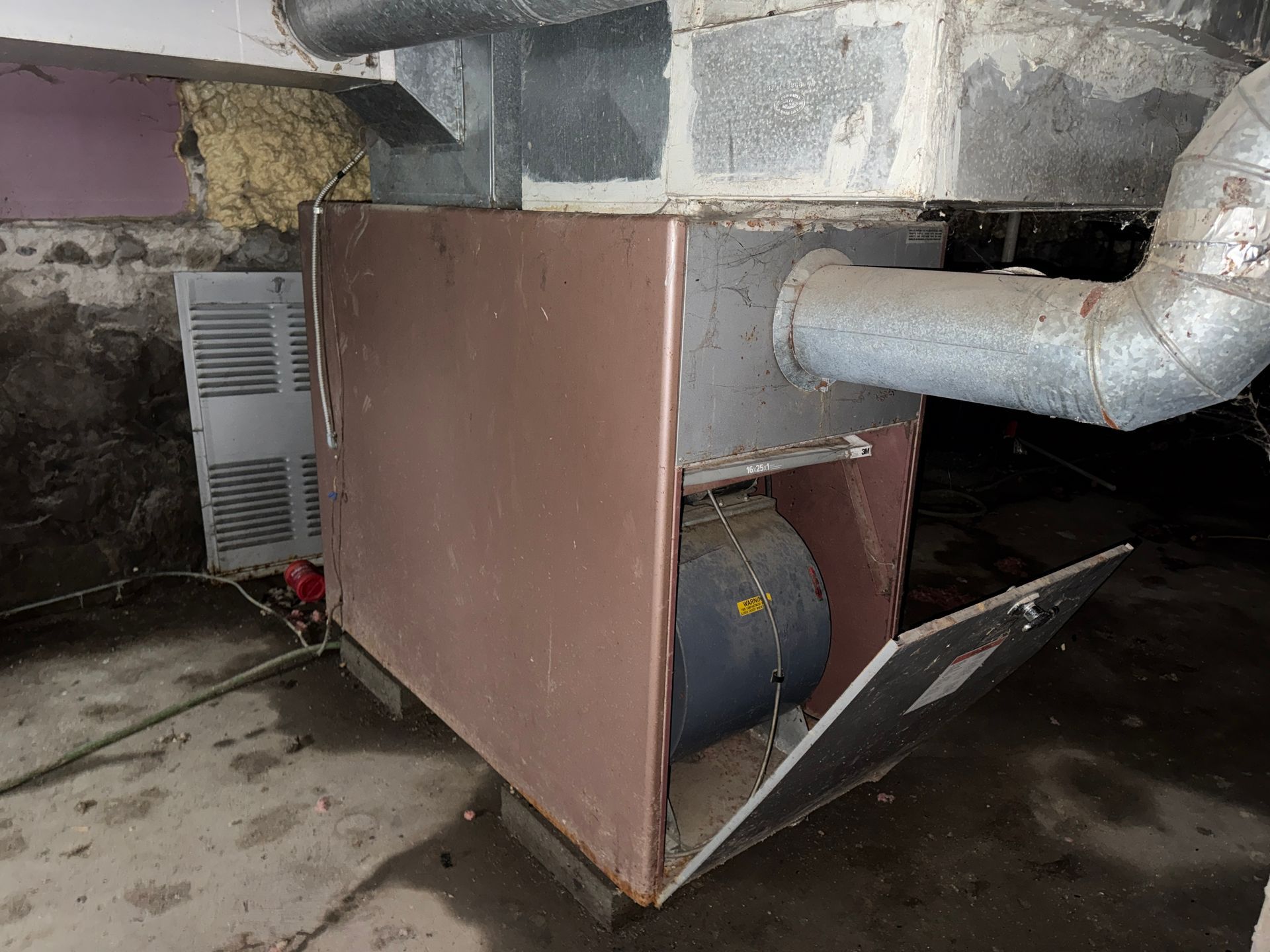 Open HVAC unit under ductwork in a basement