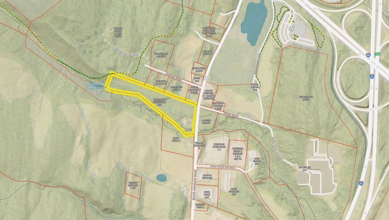 Aerial map with a view of a property in a grassy rural area near roads and buildings