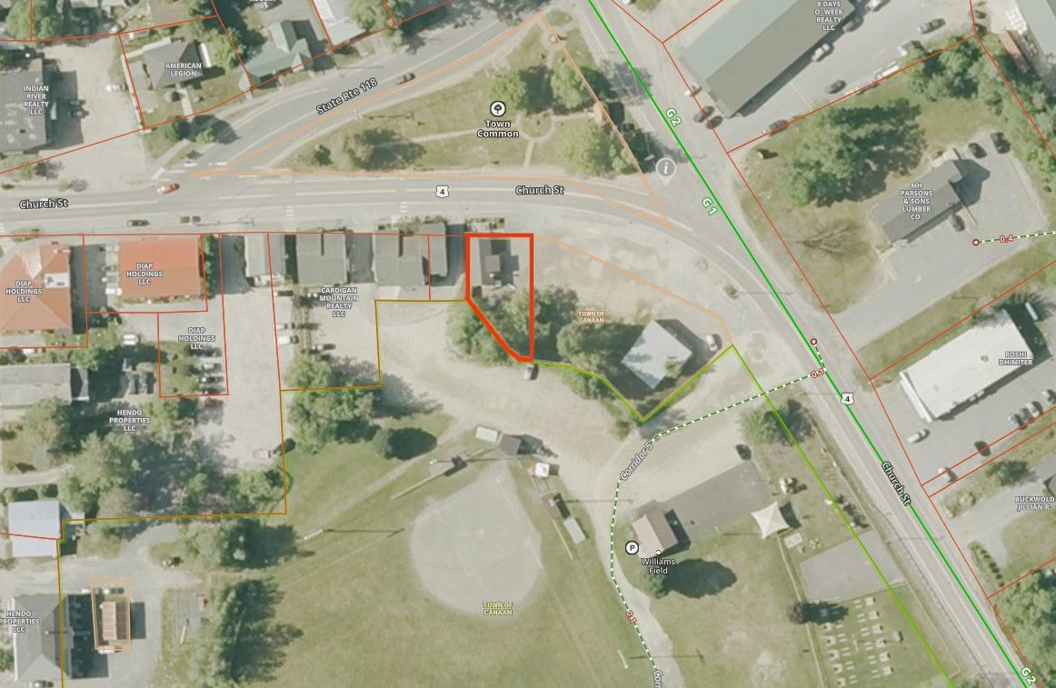 Aerial view of a commercial area, with buildings, parking, roads, and a highlighted property.