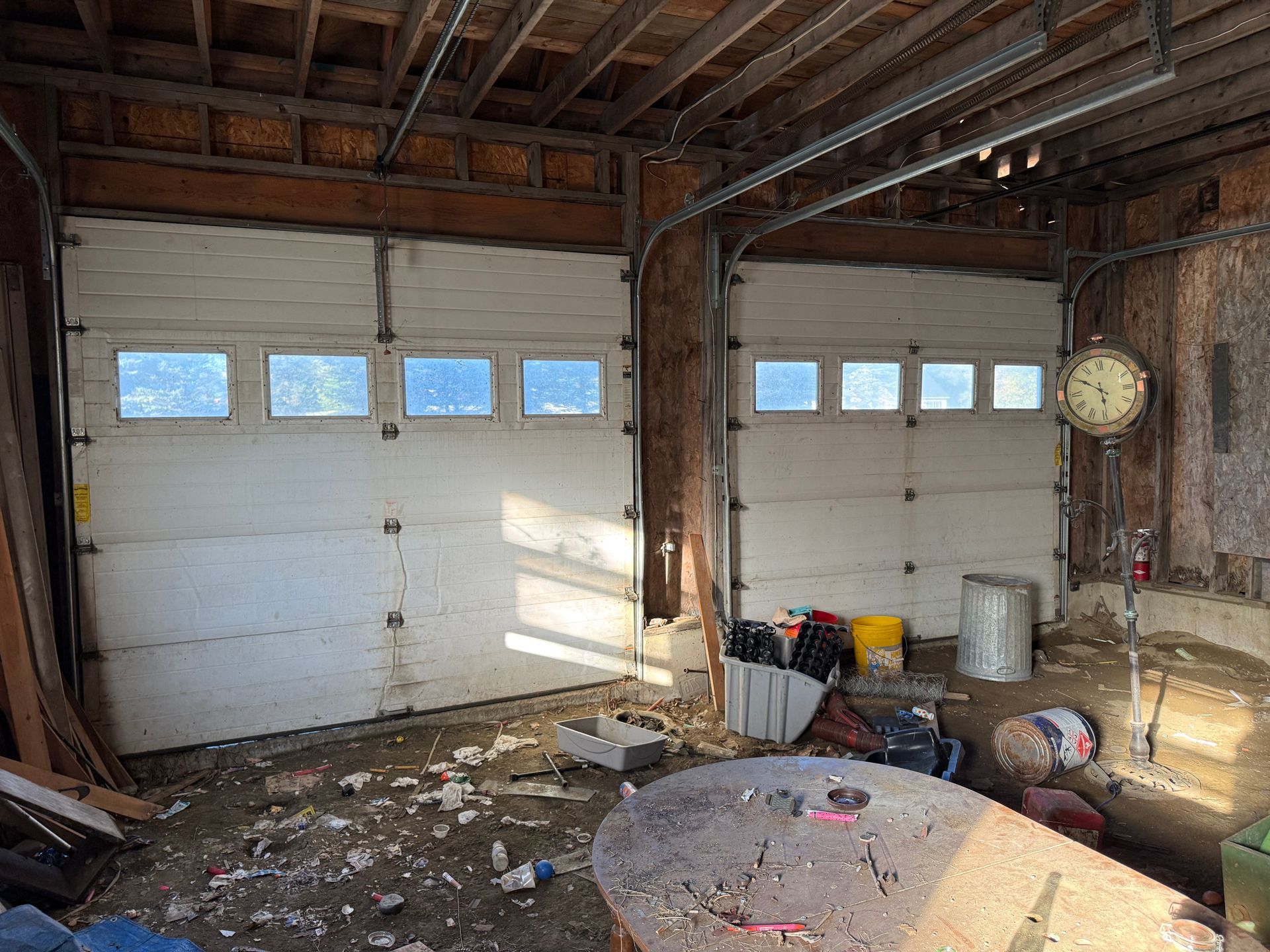 garage interior with two white overhead doors, exposed beams