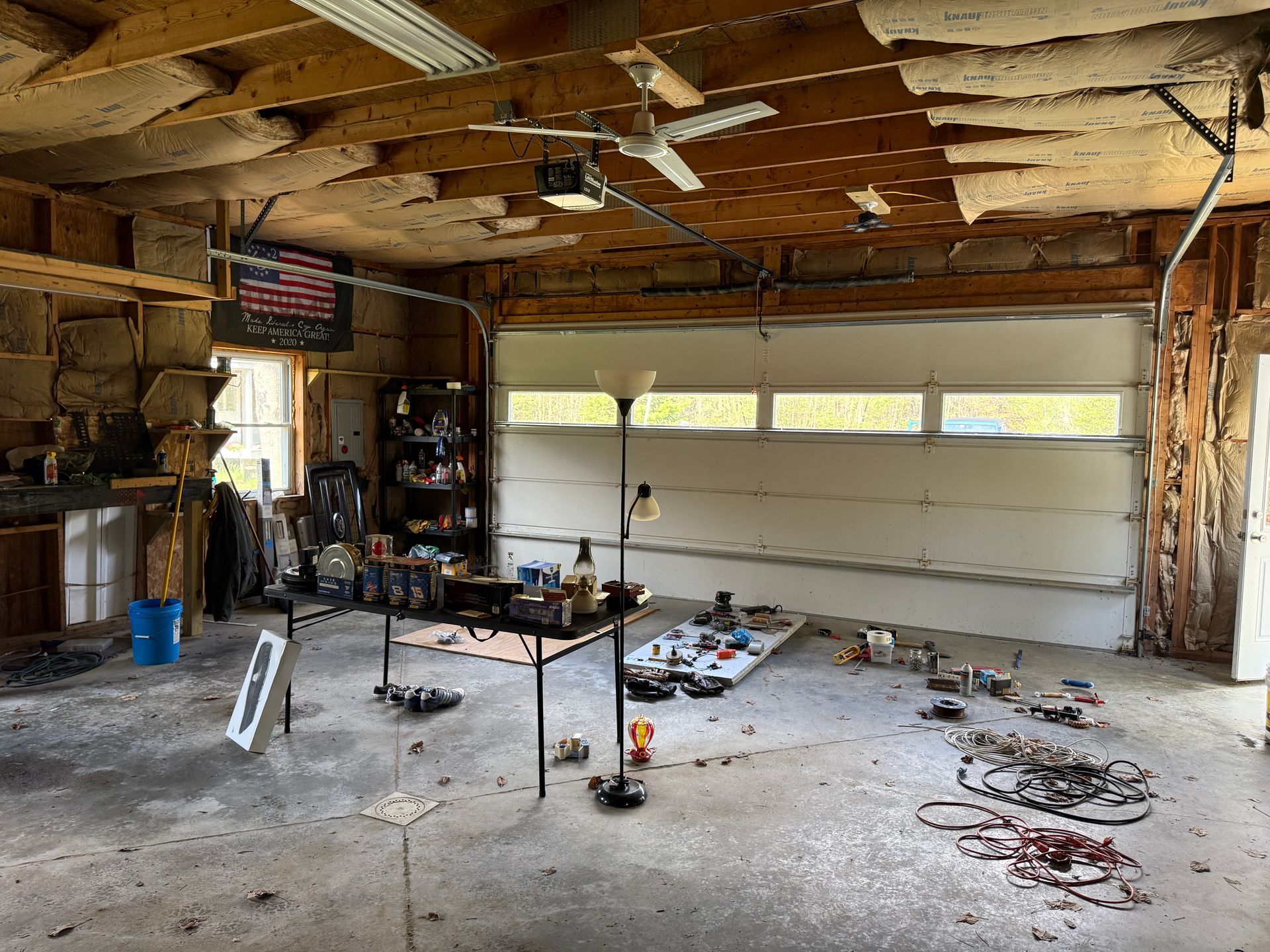 Garage with exposed ceiling beams, and a closed garage door.