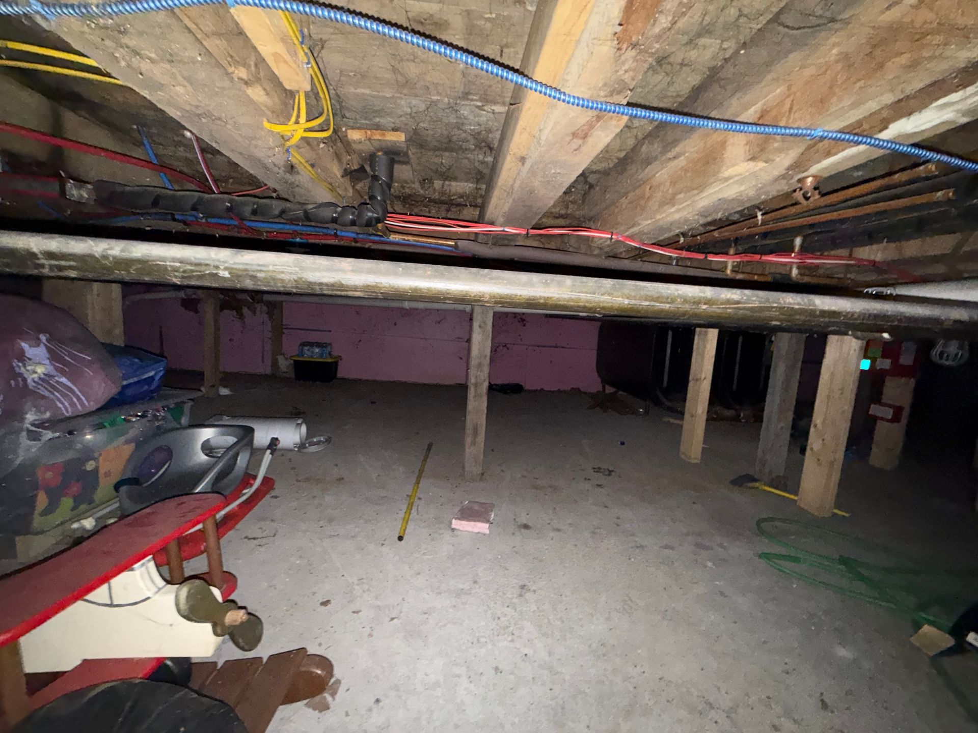 garage with concrete pillars and exposed pipes overhead.