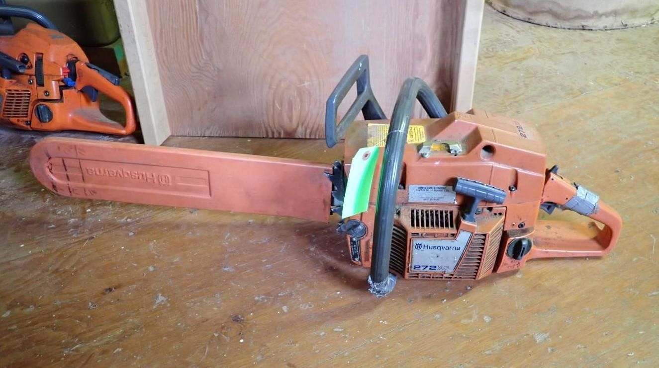 Orange-and-black chainsaw lying on a wooden surface