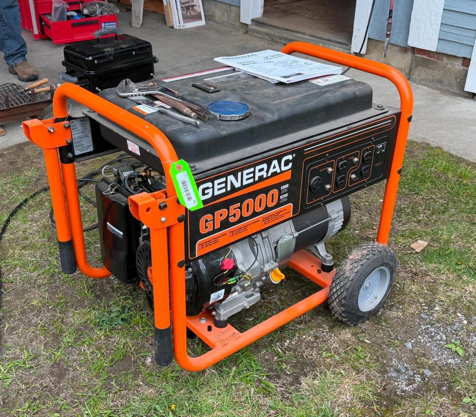 Orange Generac GP5000 portable generator on a wheeled frame outdoors on grass.