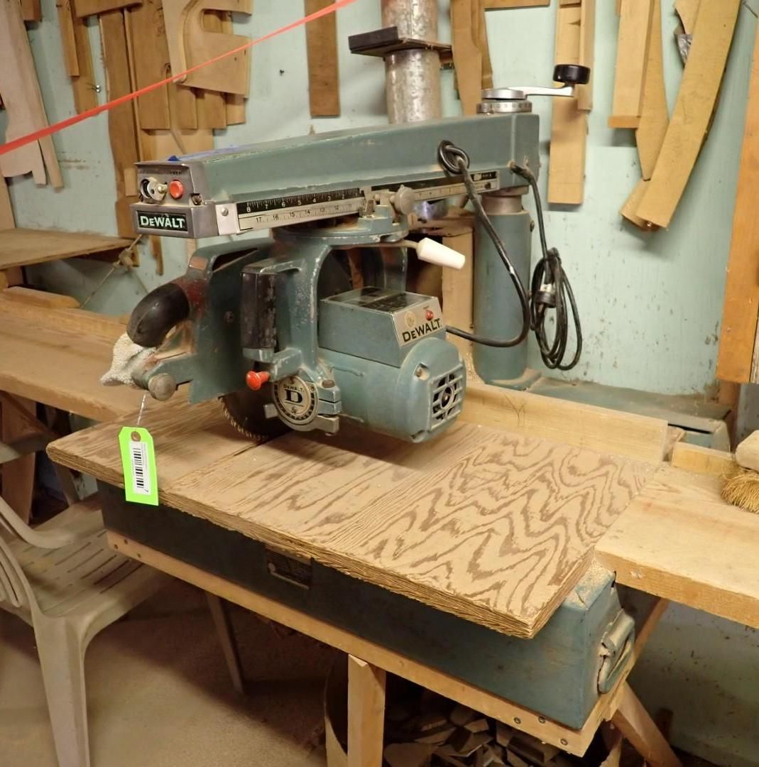 Industrial bandsaw cutting a plywood sheet in a workshop, with wood scraps in the background.