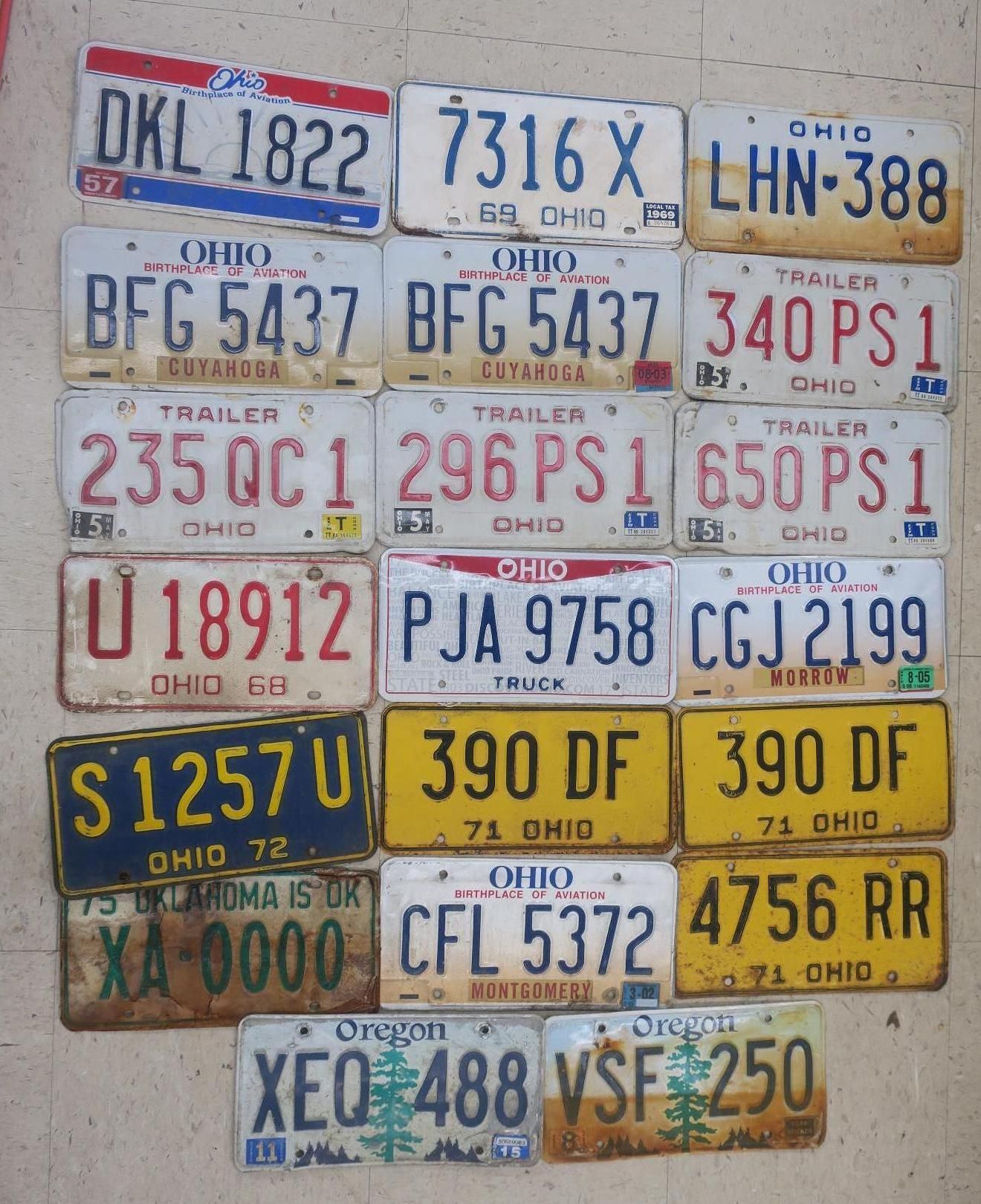 Assortment of vintage Ohio license plates arranged in a grid on a wall