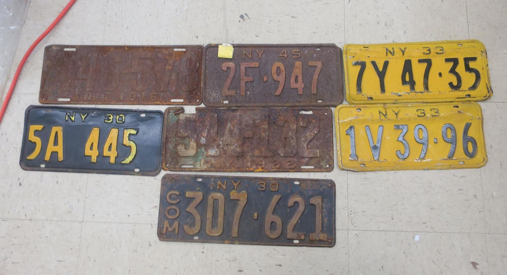 Several vintage license plates in blue, yellow, and brown on a light surface