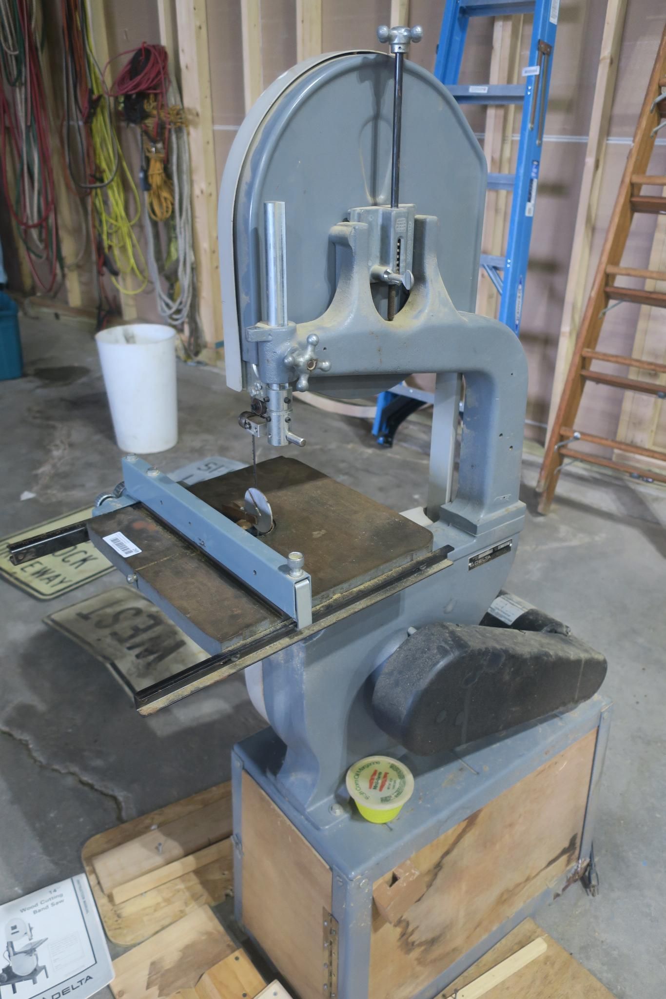 Blue-gray band saw in a workshop with a wooden base