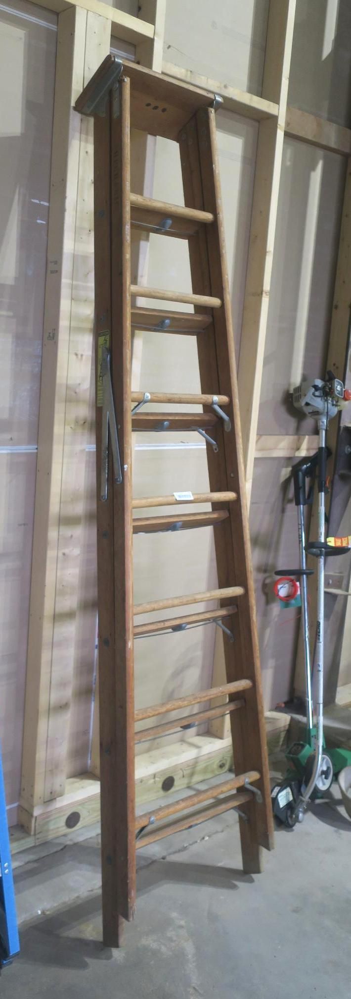 Tall wooden ladder leaning against a wall