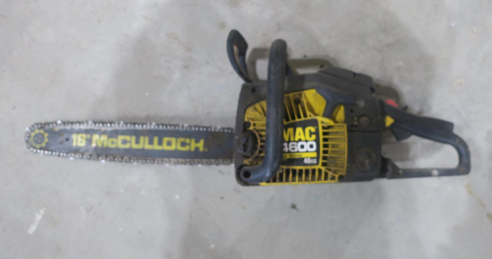 McCulloch gas chainsaw with yellow-and-black body on a gray surface