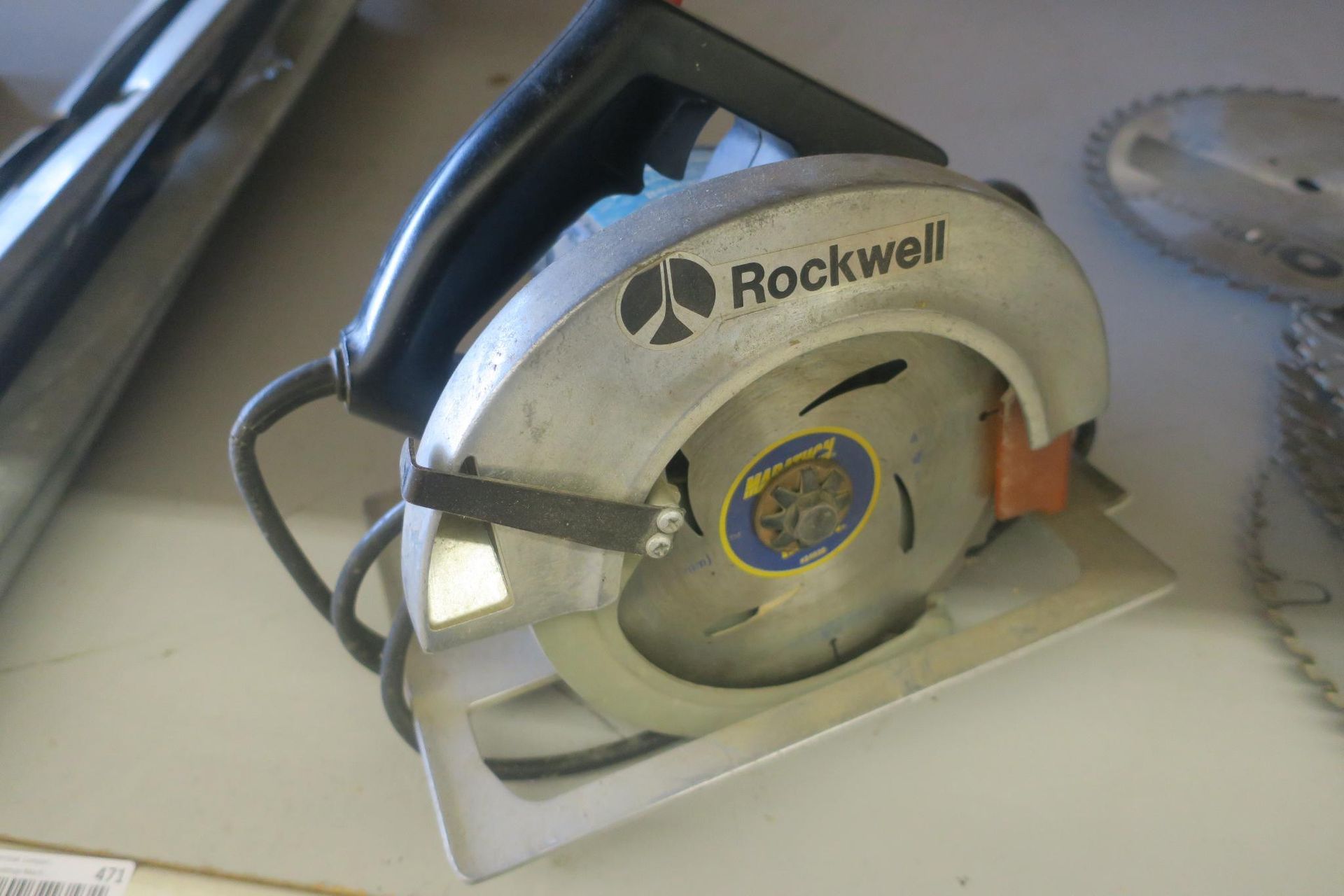 Rockwell circular saw resting on a workbench with a black handle and silver blade guard