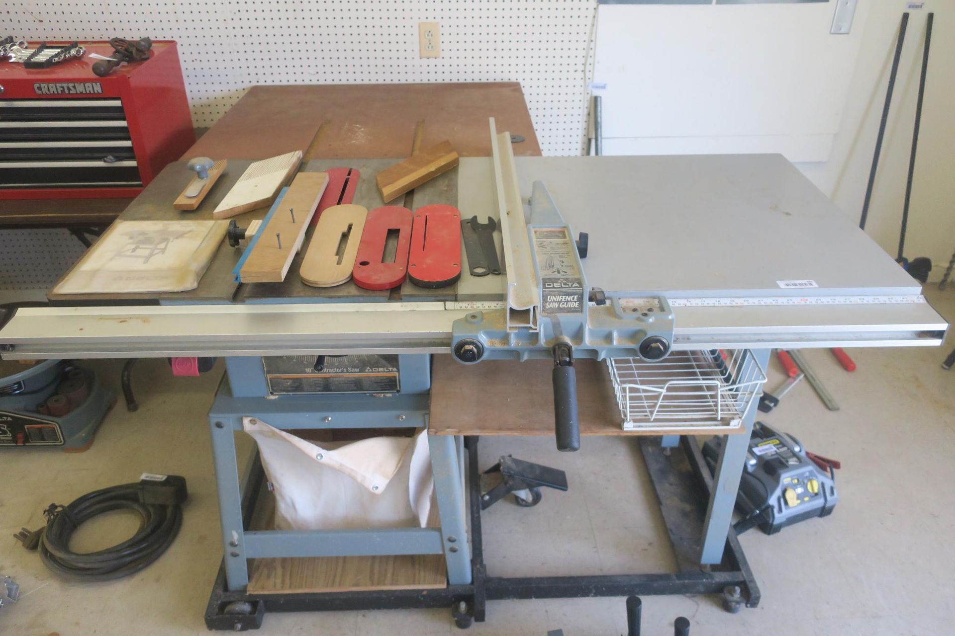 Table saw in a workshop with wood pieces and tools on a workbench
