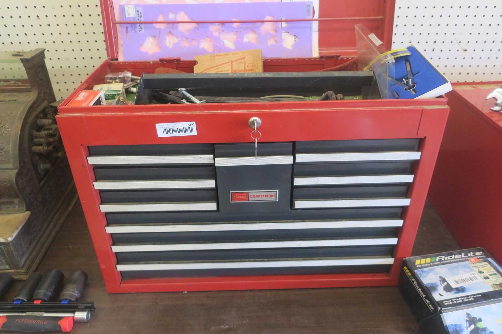 Red tool chest with multiple drawers on a workbench in a garage or workshop