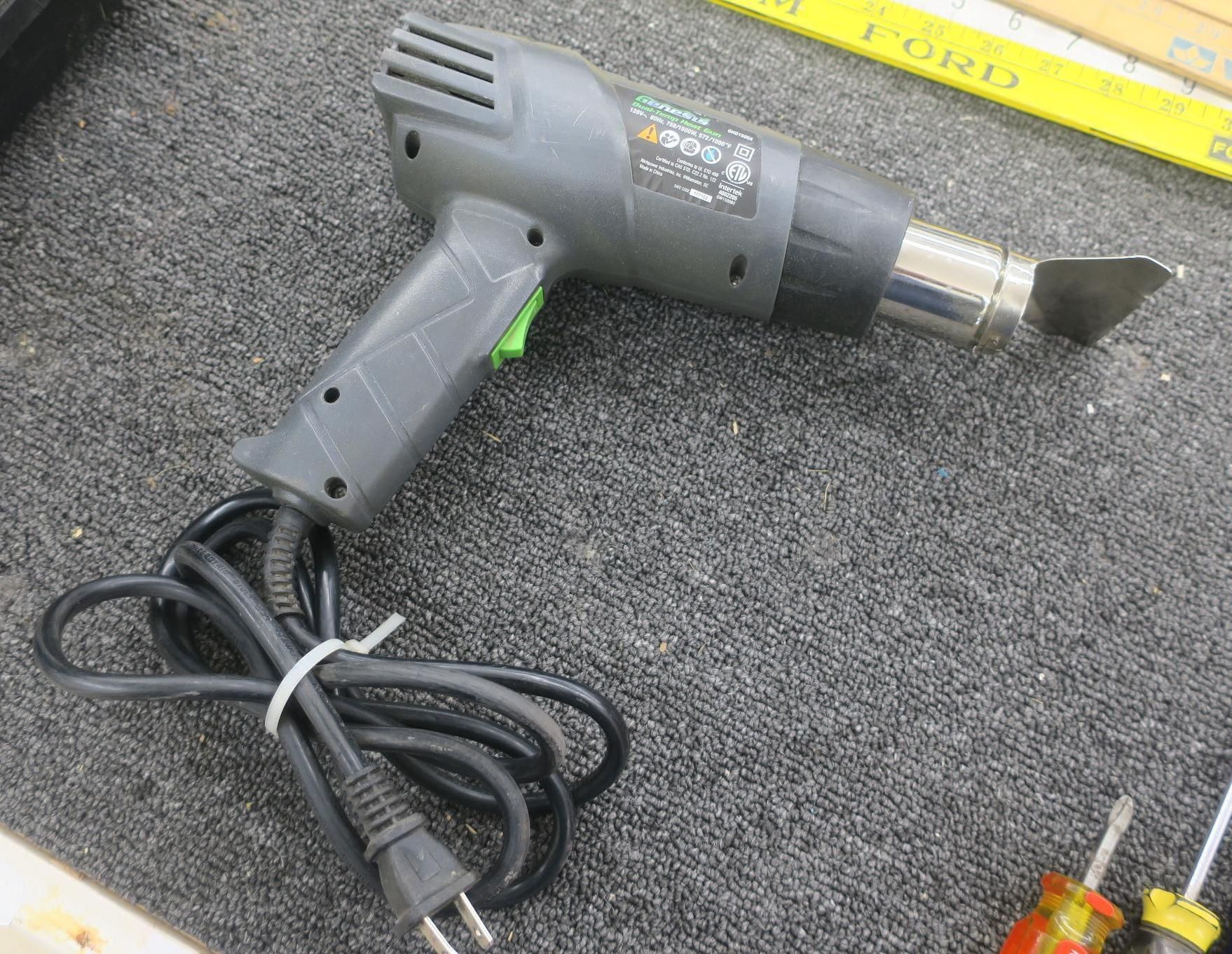 Gray heat gun with power cord on a carpeted surface