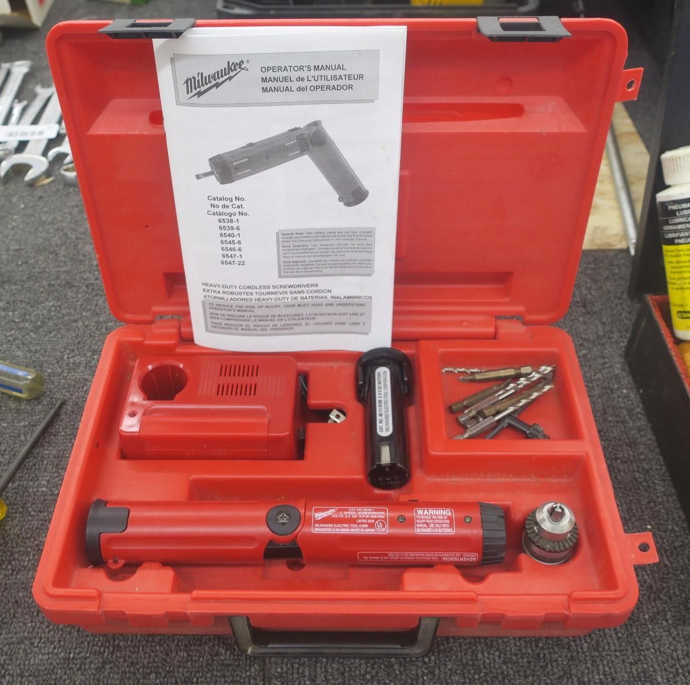Red Milwaukee tool kit in a hard case with attachments and instruction sheet.