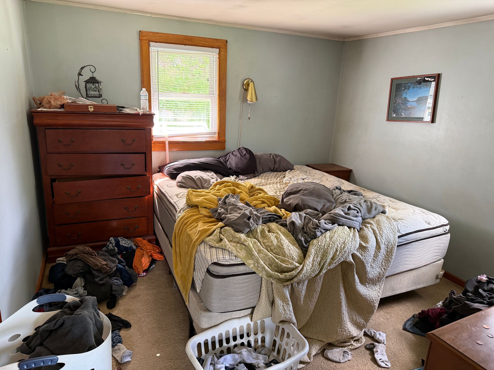 bedroom with bed, dresser, and window with blinds.