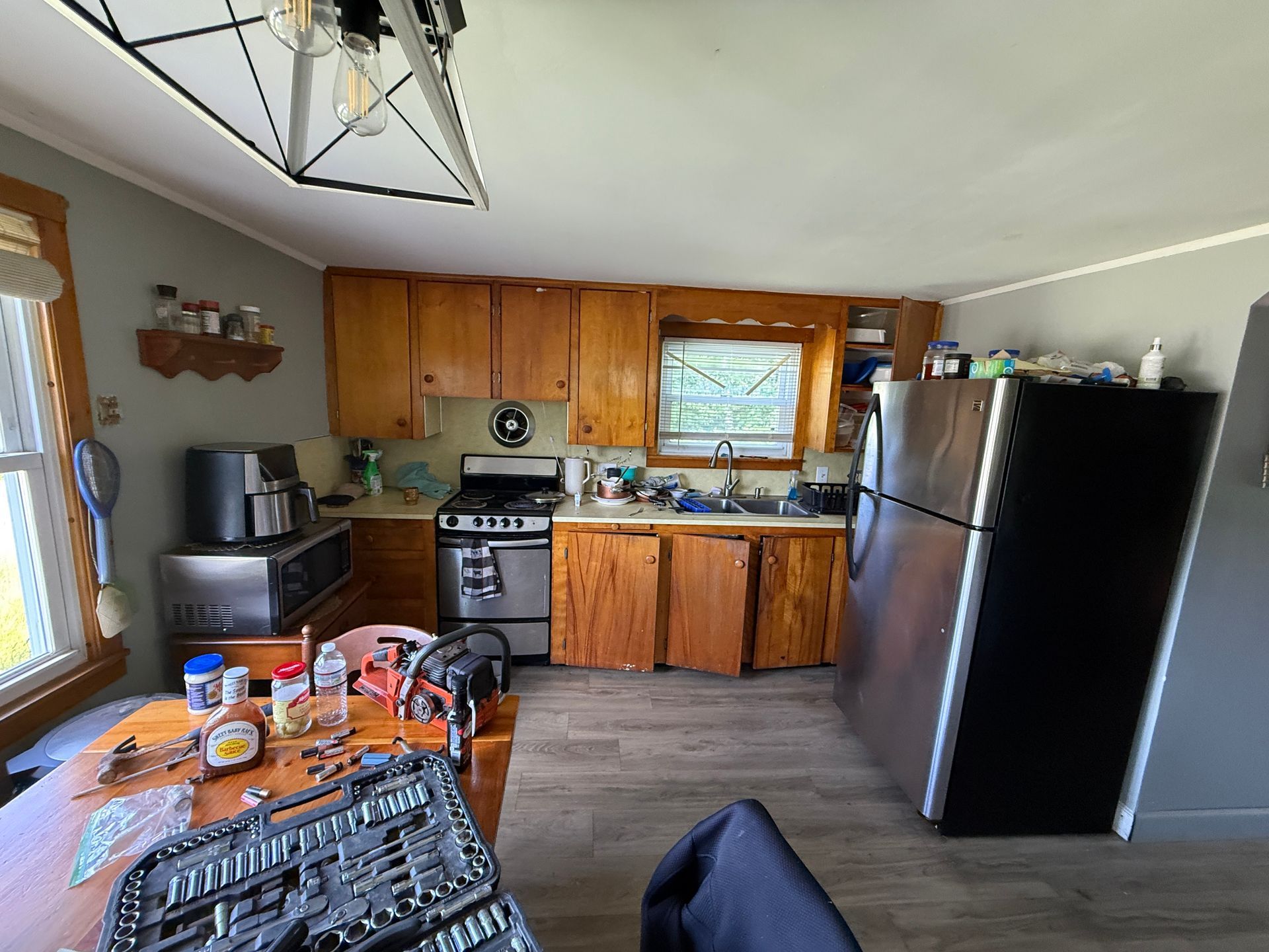 Kitchen interior with wood cabinets, stainless steel fridge, stove, and countertop