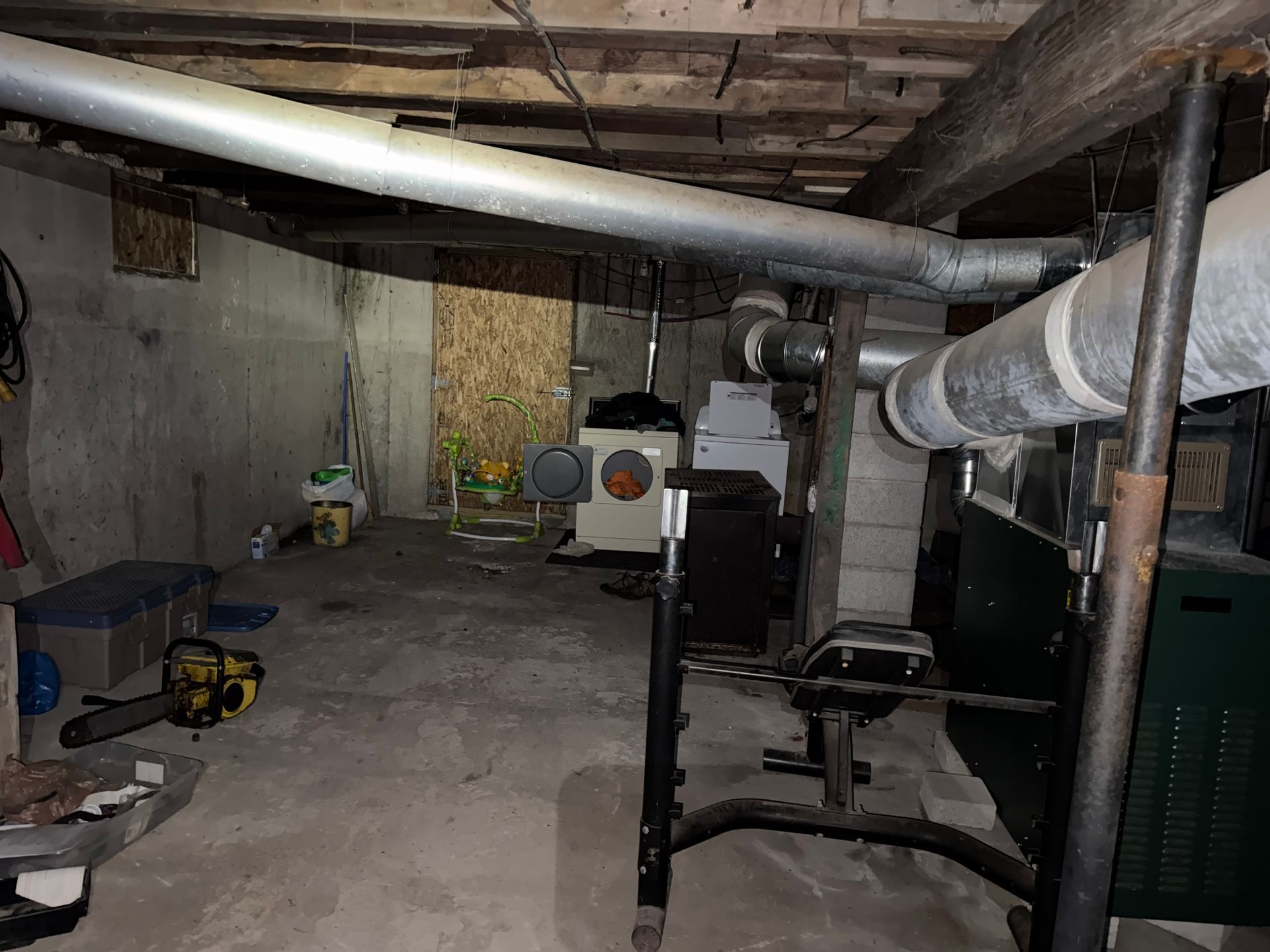 Basement utility room with exposed pipes, furnace, washer