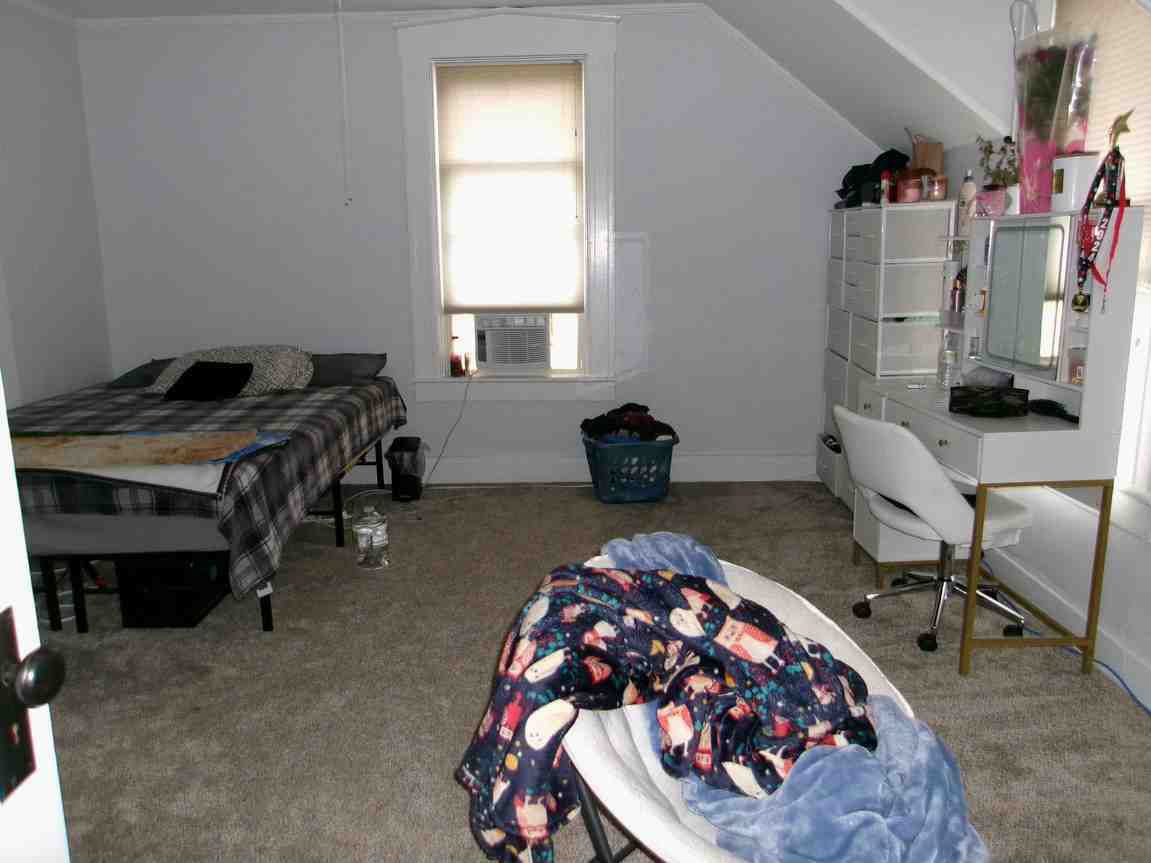 Bedroom with two beds, a window, and a white desk