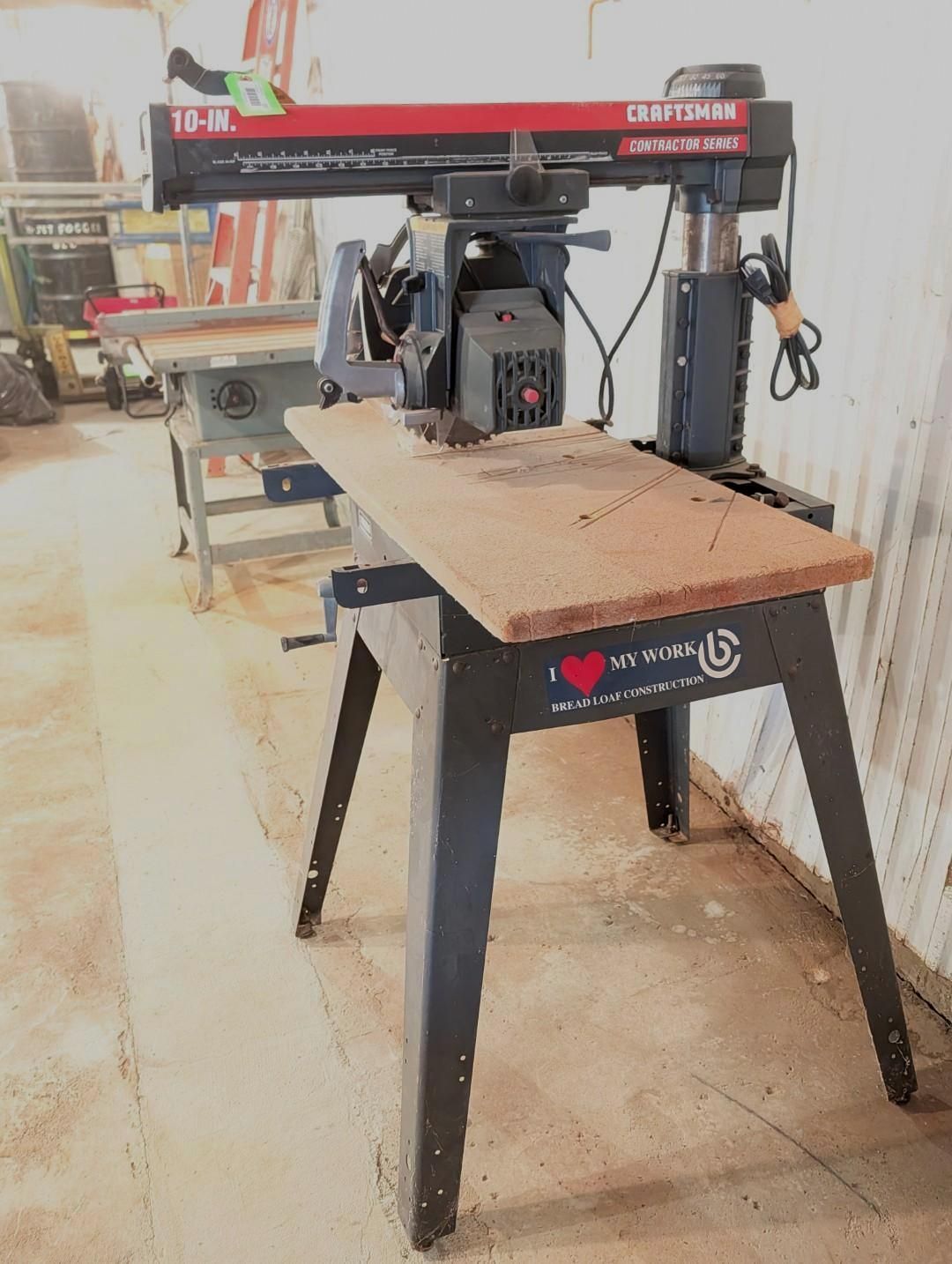 Woodworking router table with red overhead gantry in a workshop