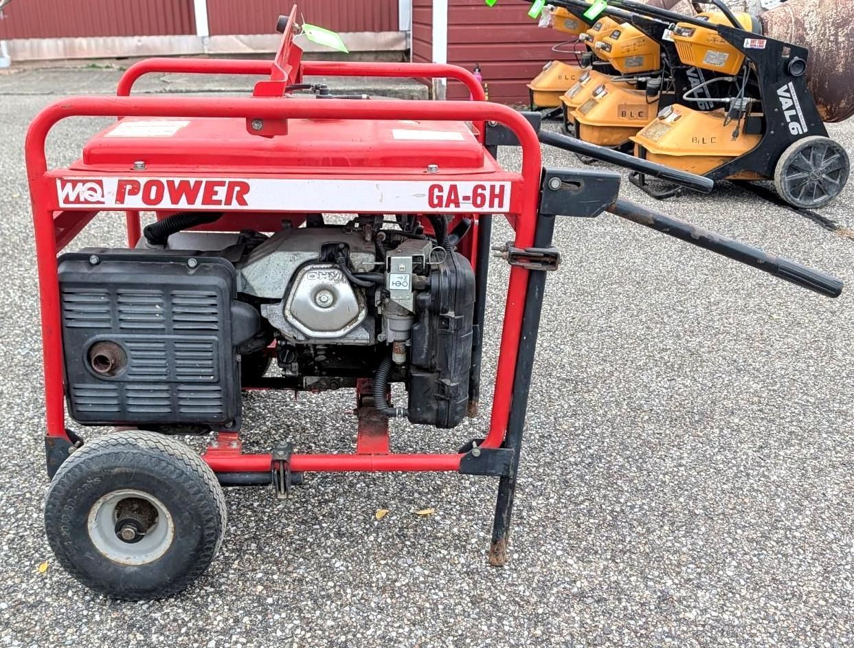 Red portable generator in a metal frame on gravel